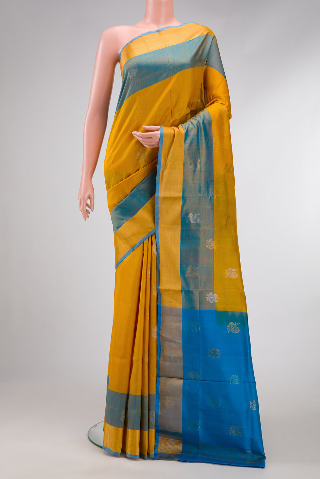 Mustard Dual Tone Uppada Silk Saree with Zari Butta on the body and Zari Border.  displayed on a mannequin