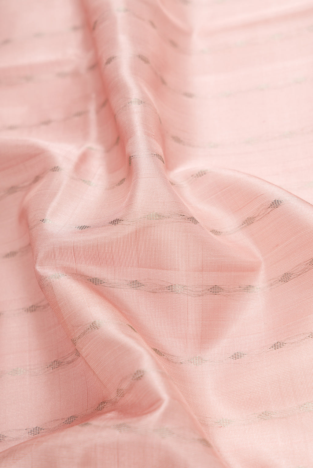 Close up of Rose Gold Dual Tone Uppada Silk Saree with Zari Butta on the body and Zari Border.  displaying folds