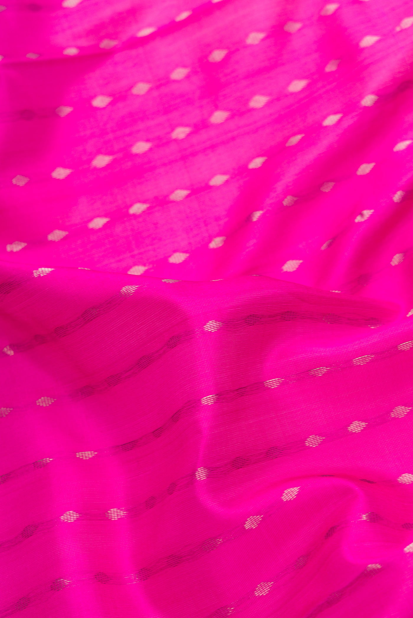 Close up of Dark Pink Dual Tone Uppada Silk Saree with Zari Butta on the body and Zari Border.  displaying folds