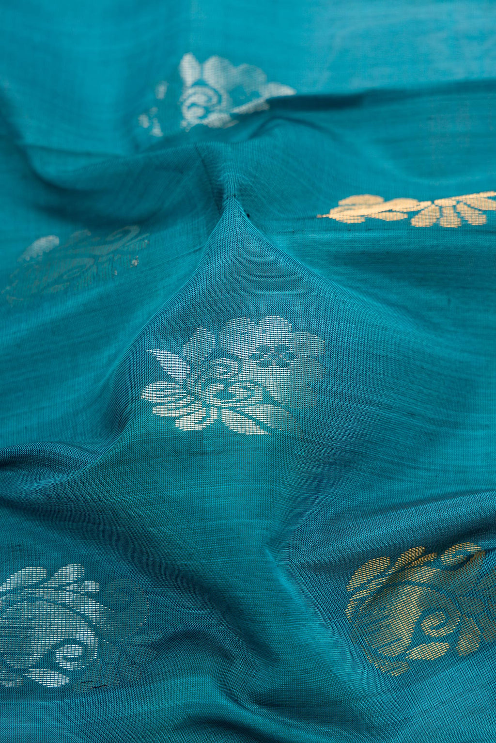 Close up of Peacock Blue Dual Tone Uppada Silk Saree with Zari Butta on the body and Zari Border.  displaying folds