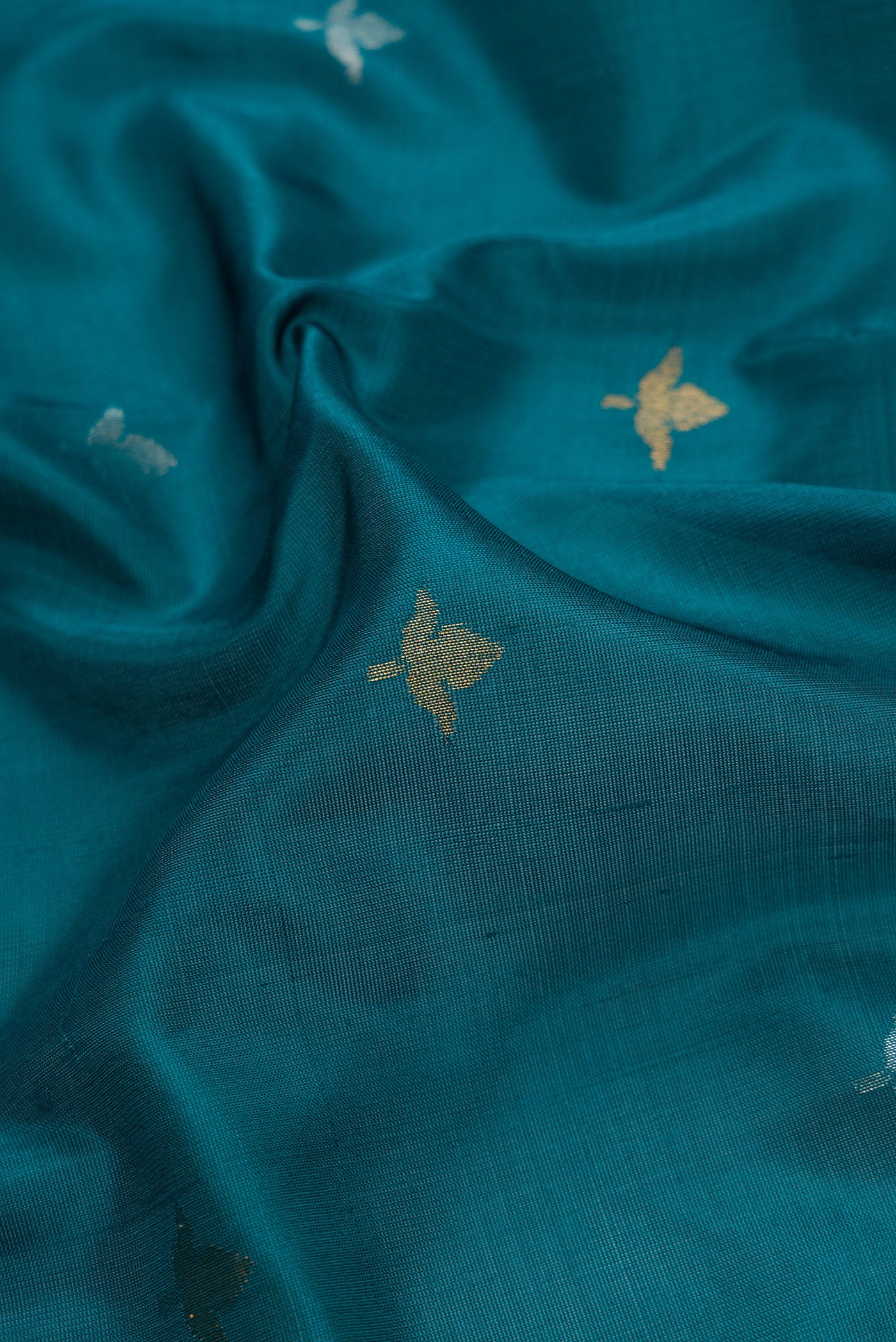 Close up of Maya Blue Dual Tone Uppada Silk Saree with Zari Butta on the body and Zari Border.  displaying folds