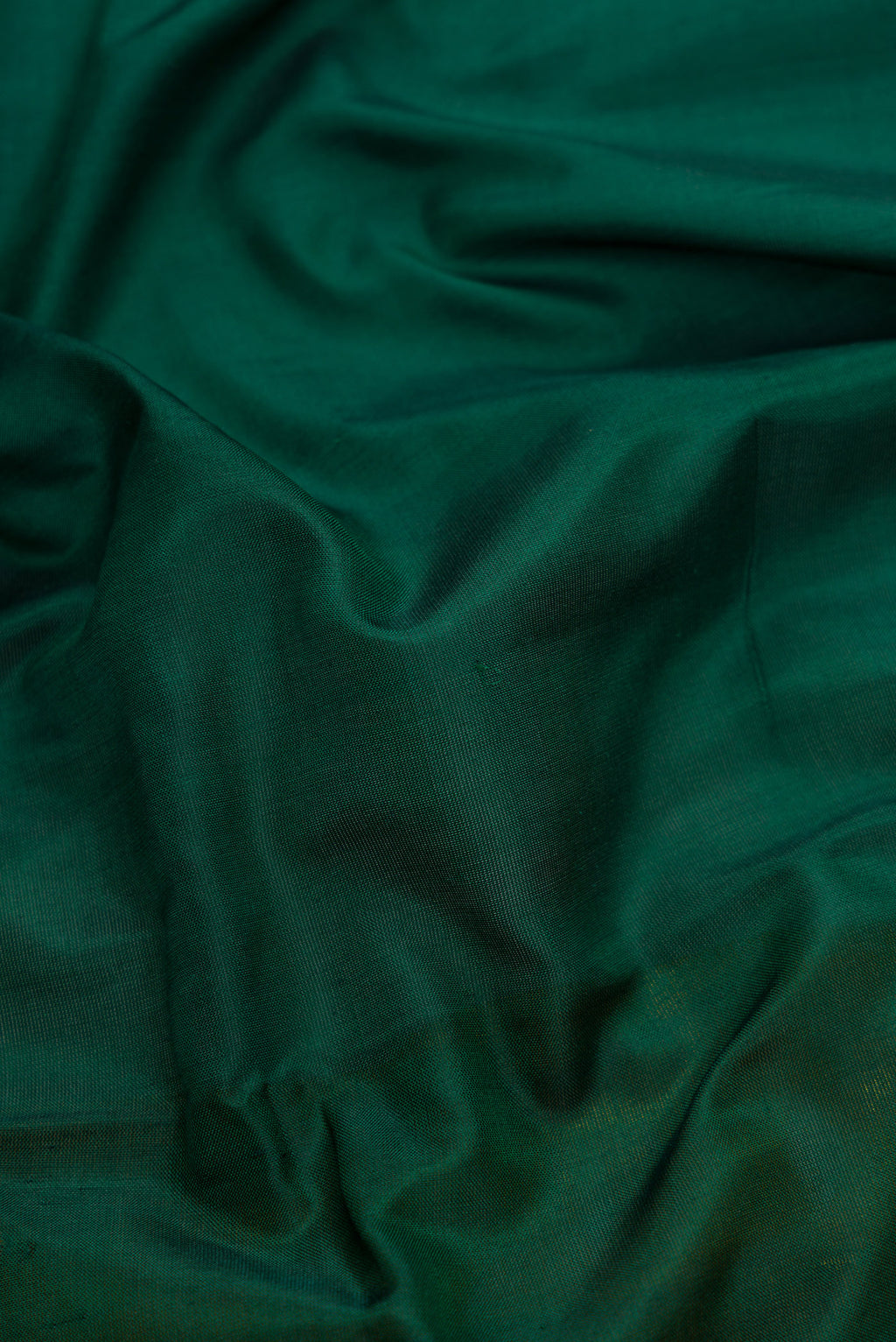 Close up of Green Dual Tone Uppada Silk Saree with Zari Butta on the body and Zari Border.  displaying folds