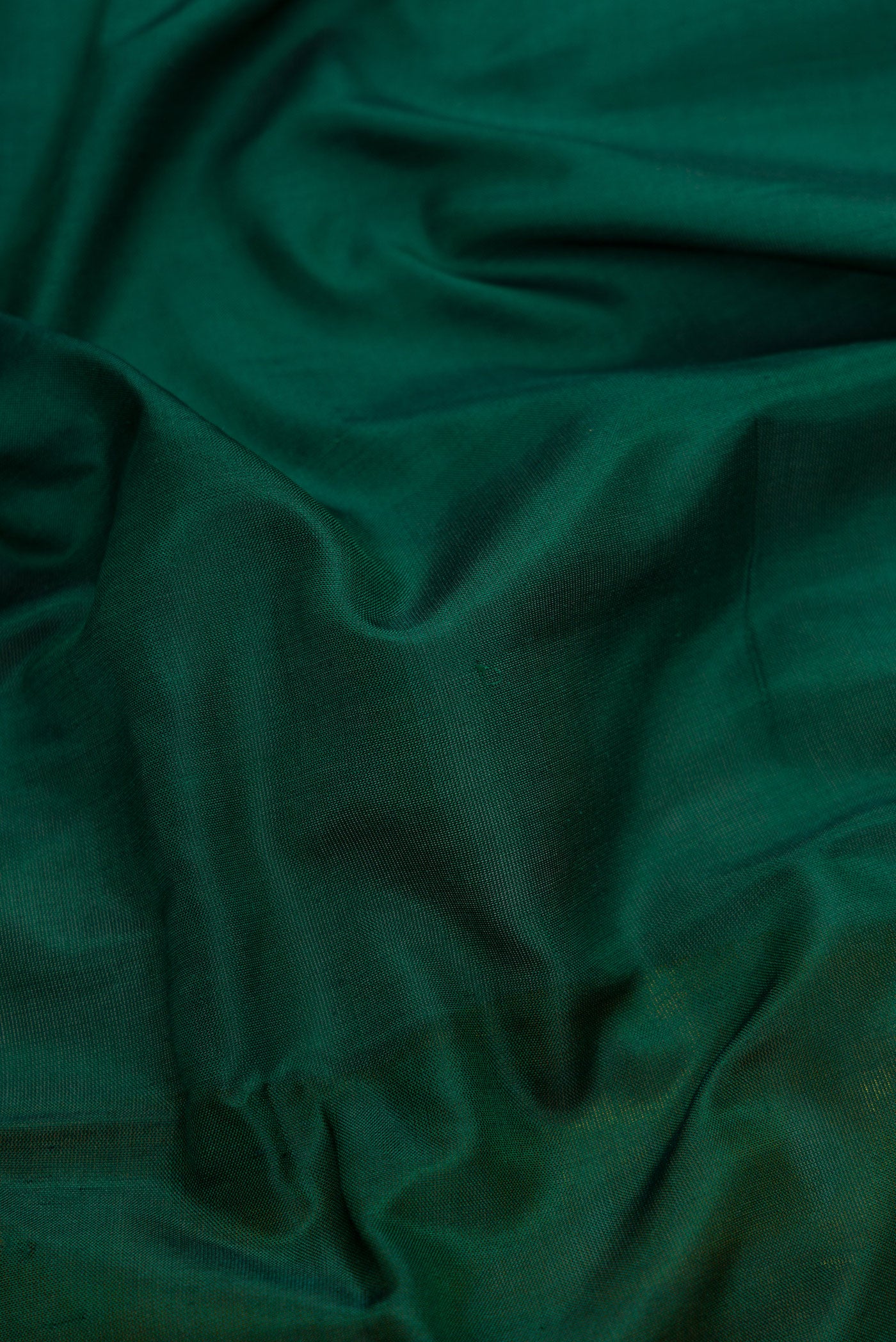 Close up of Green Dual Tone Uppada Silk Saree with Zari Butta on the body and Zari Border.  displaying folds