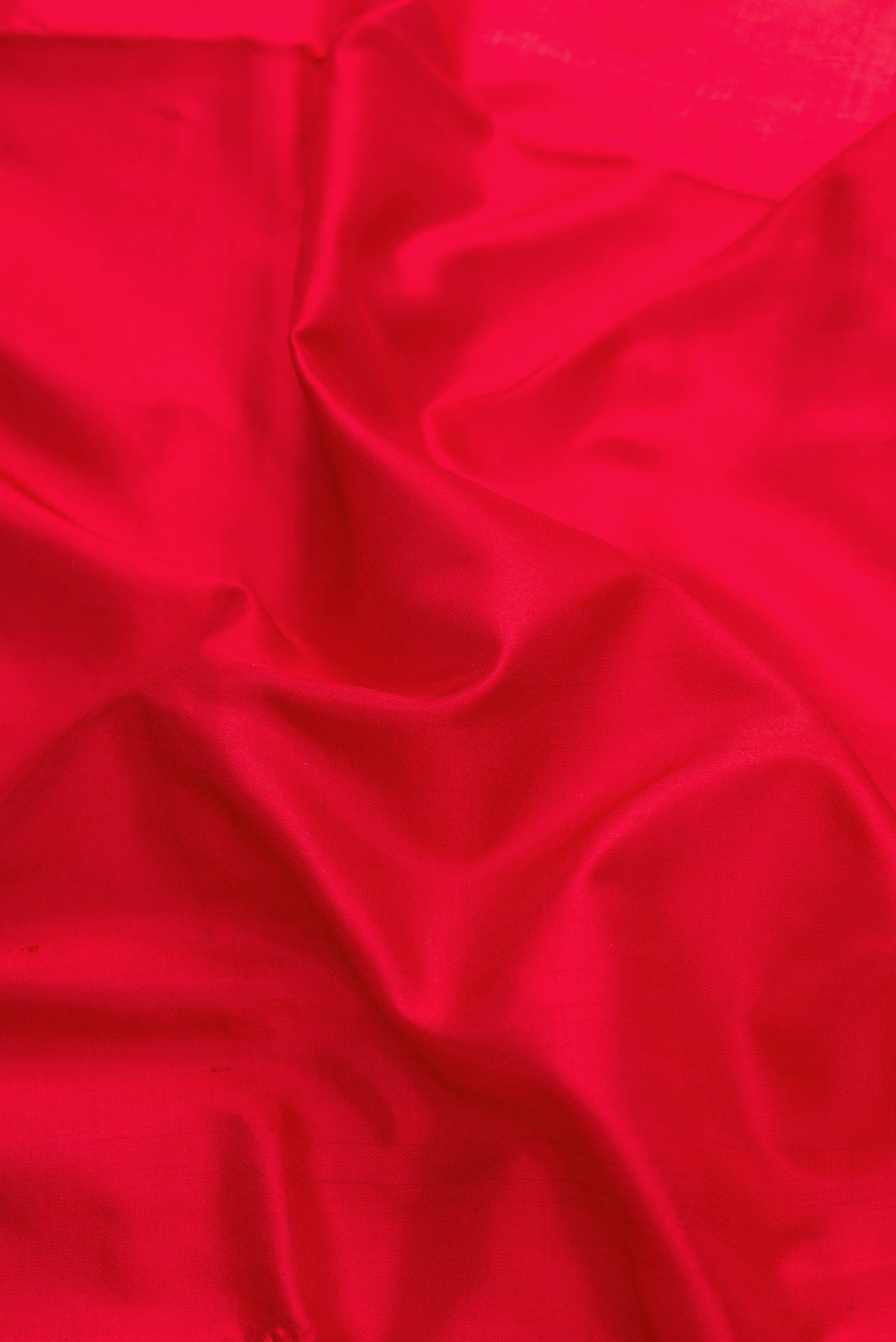 Close up of Red Dual Tone Uppada Silk Saree with Plain Body and Zari Border.  displaying folds