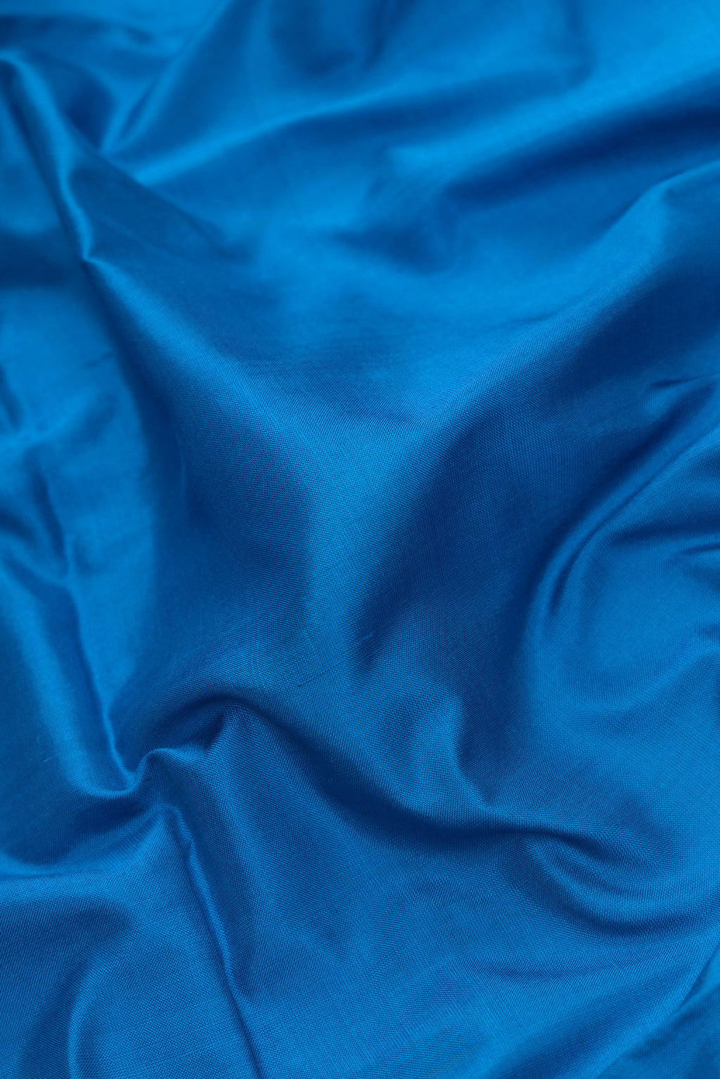 Close up of Peacock Blue Dual Tone Uppada Silk Saree with Plain Body and Zari Border.  displaying folds