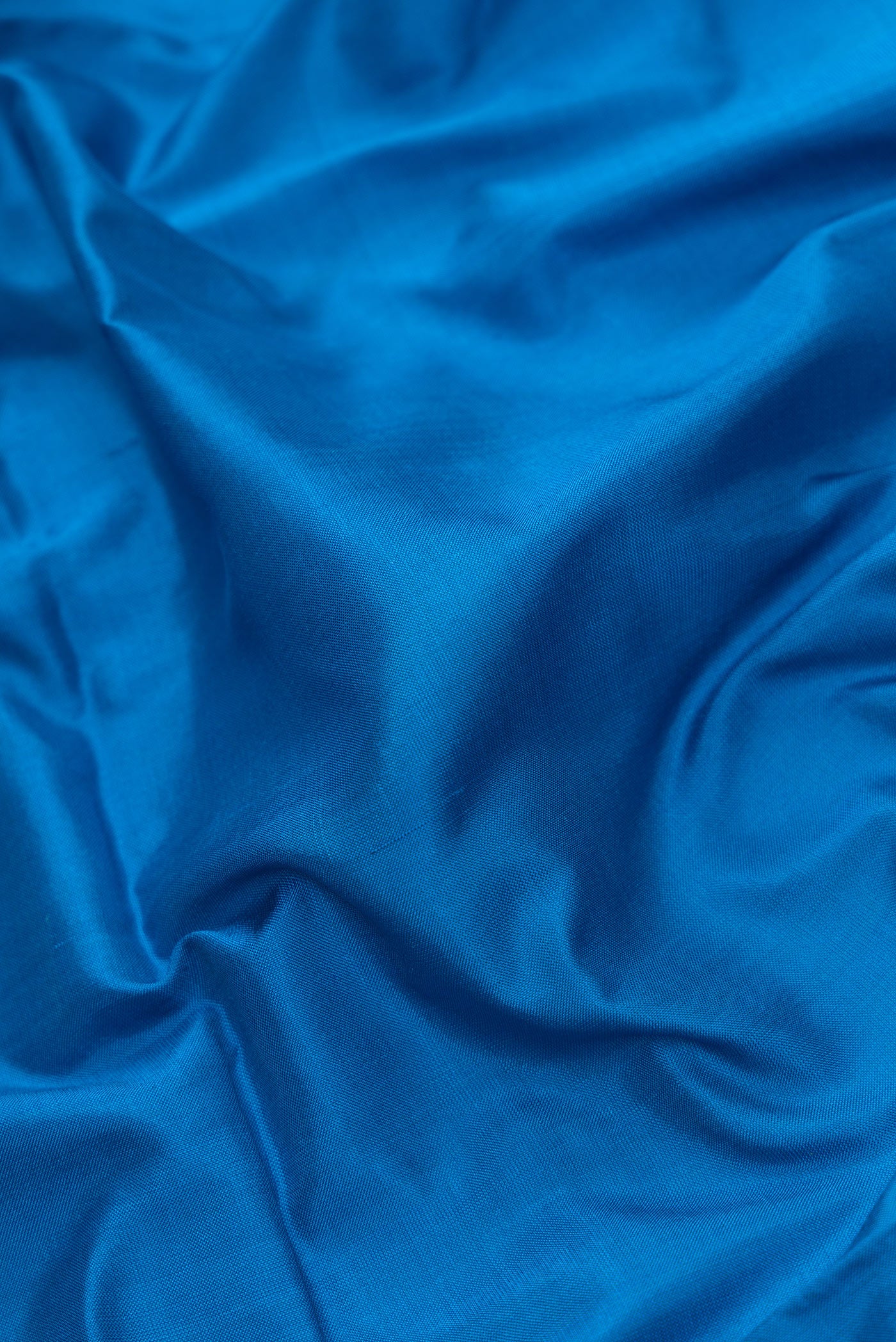 Close up of Peacock Blue Dual Tone Uppada Silk Saree with Plain Body and Zari Border.  displaying folds