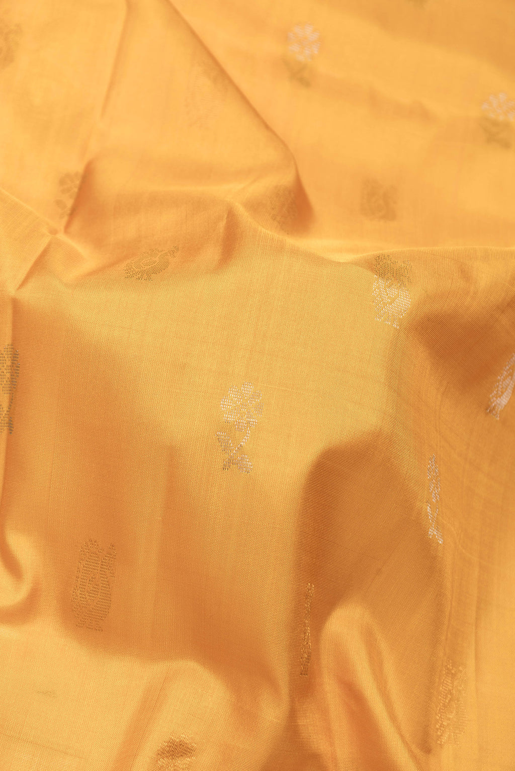 Close up of Mustard Dual Tone Uppada Silk Saree with Zari Butta on the body and Zari Border.  displaying folds
