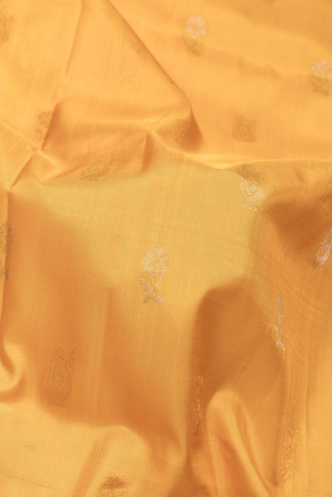 Close up of Mustard Dual Tone Uppada Silk Saree with Zari Butta on the body and Zari Border.  displaying folds