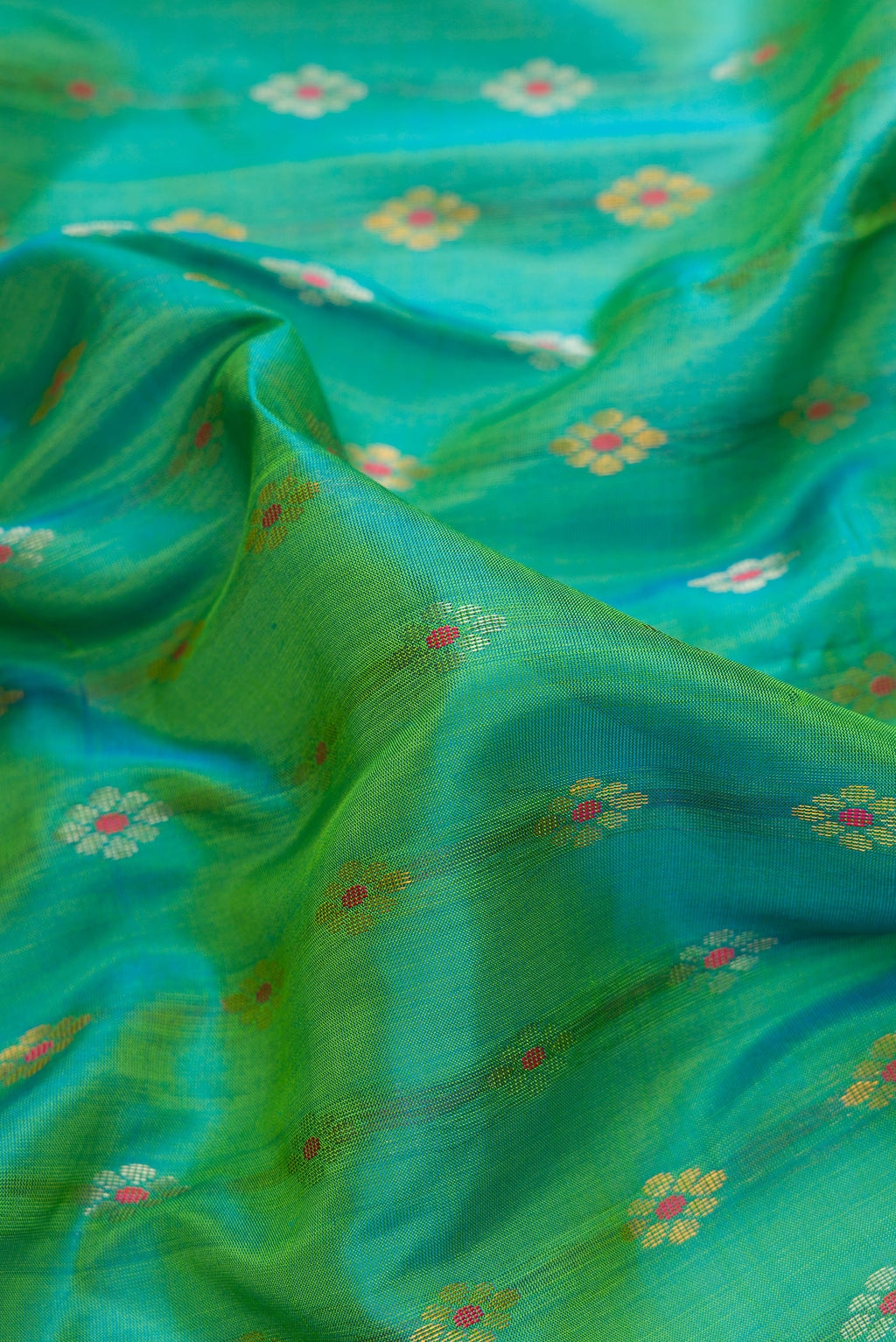 Close up of Sea Green Dual Tone Uppada Silk Saree with Zari Butta on the body and Zari Border.  displaying folds