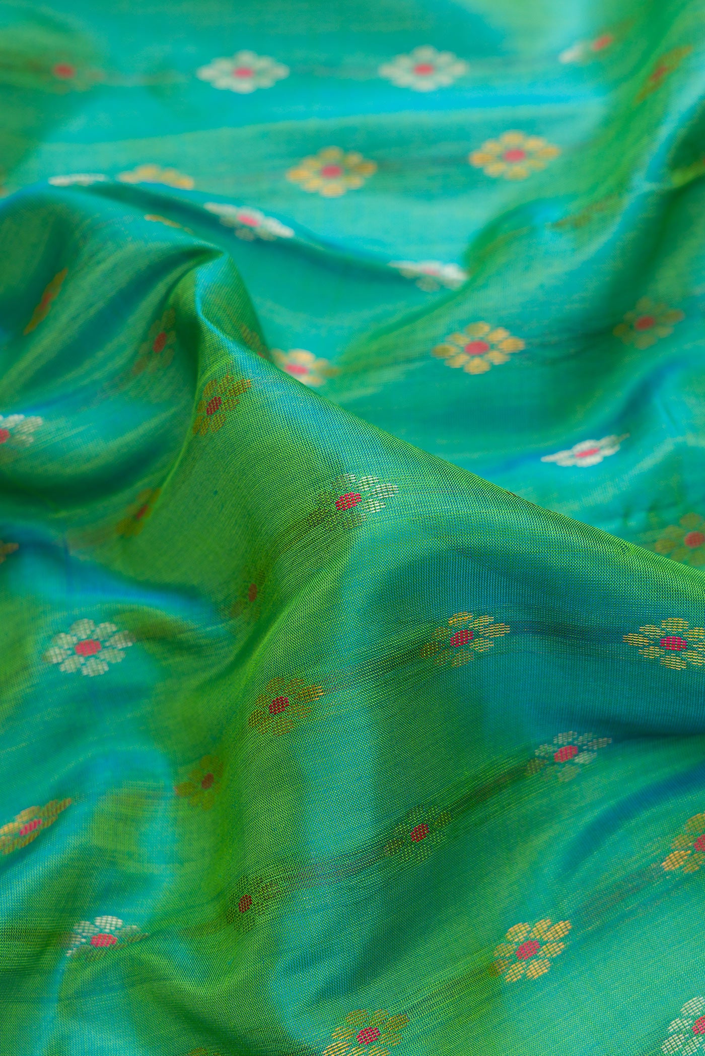 Close up of Sea Green Dual Tone Uppada Silk Saree with Zari Butta on the body and Zari Border.  displaying folds
