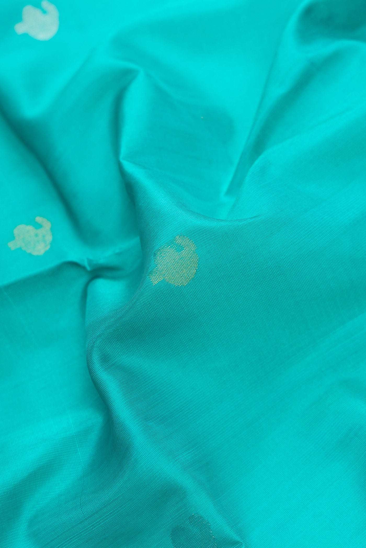 Close up of Sea Green Dual Tone Uppada Silk Saree with Zari Butta on the body and Zari Border.  displaying folds