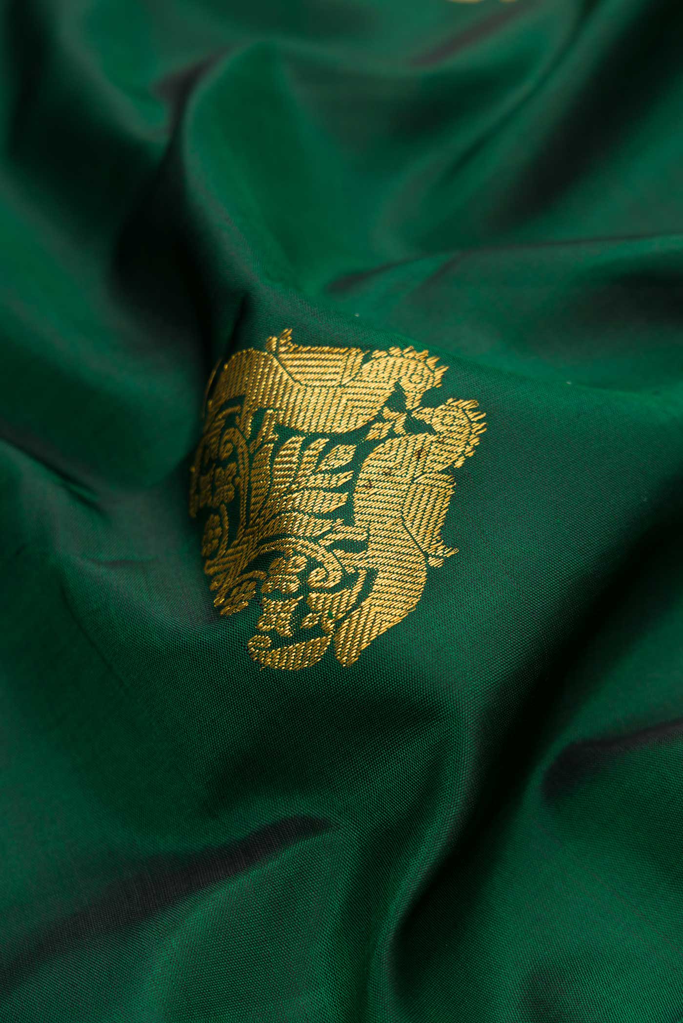 Close up of Bottle Green Dual Tone Kanchipuram Silk Saree with Zari Butta on the body and Plain Border.  displaying folds