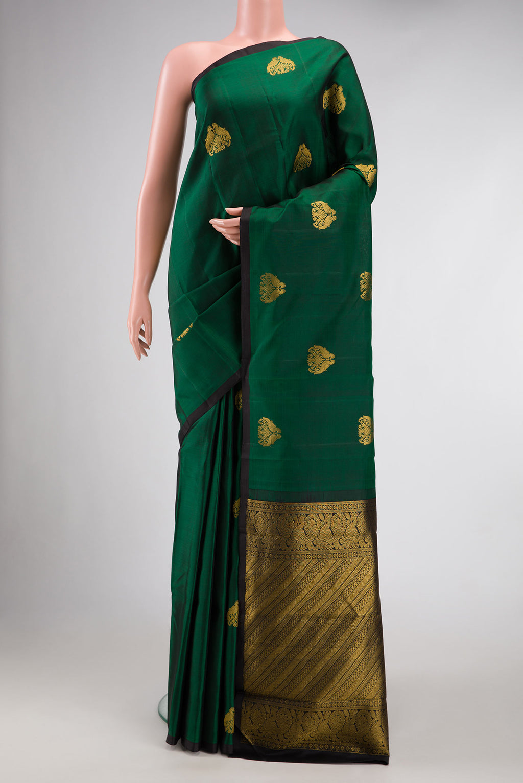 Bottle Green Dual Tone Kanchipuram Silk Saree with Zari Butta on the body and Plain Border.  displayed on a mannequin