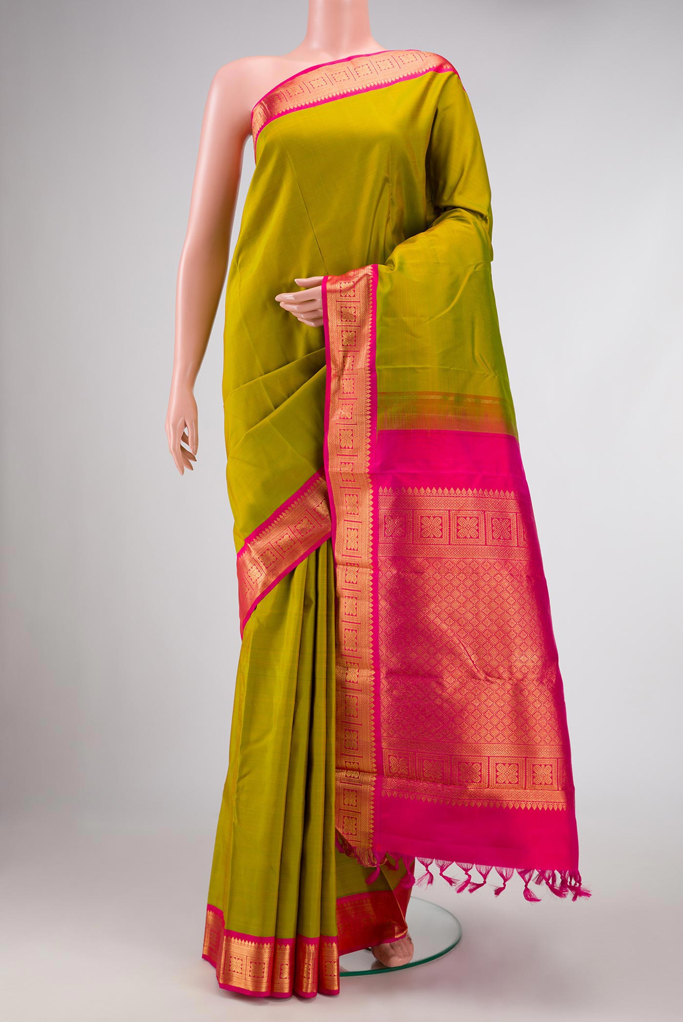 Mehandi Green Dual Tone Kanchipuram Silk Saree with Plain Body and Zari Border displayed on a mannequin