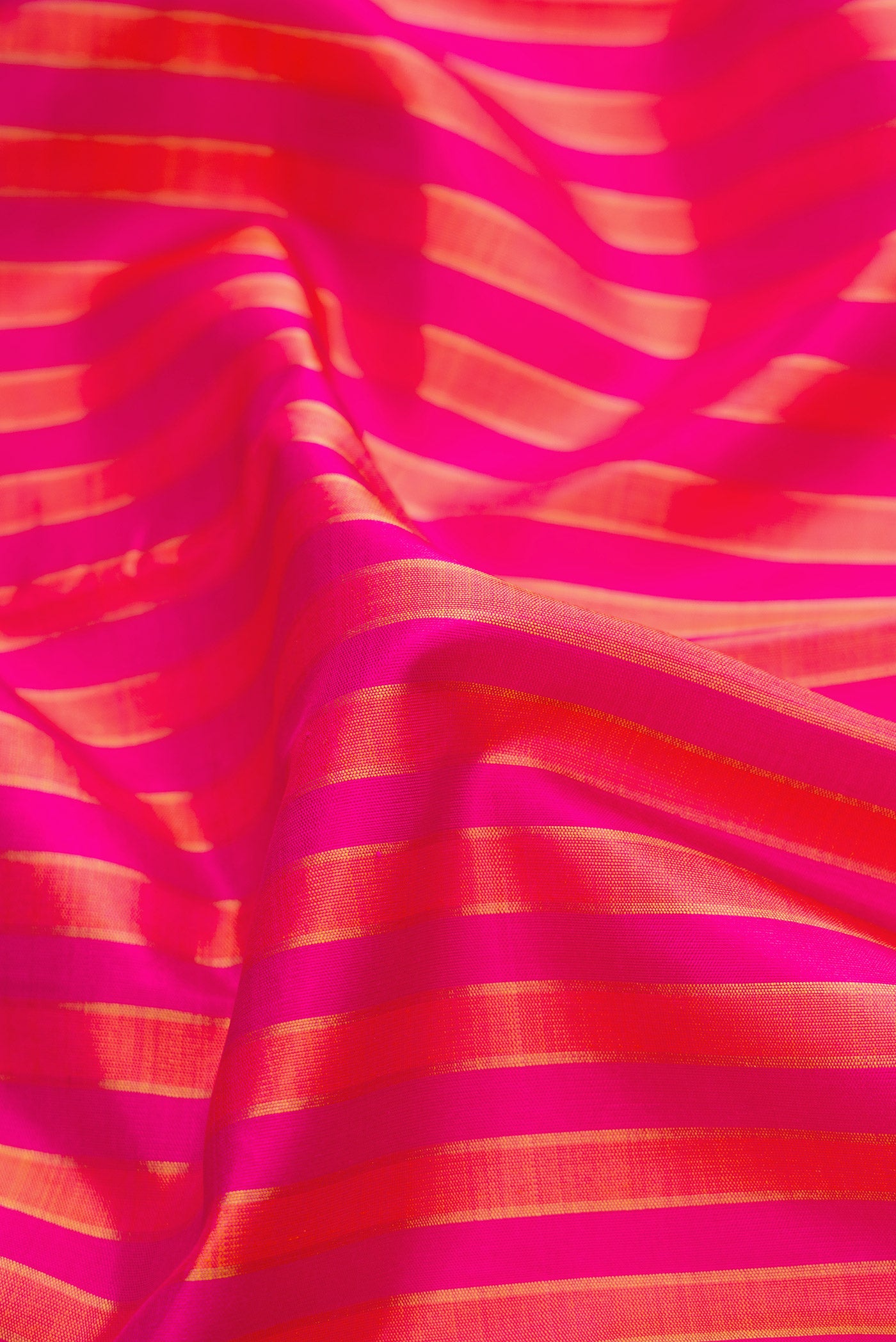 Close up of Pink Dual Tone Kanjivaram Silk Saree with Stripes on the body and Zari Border.  displaying folds