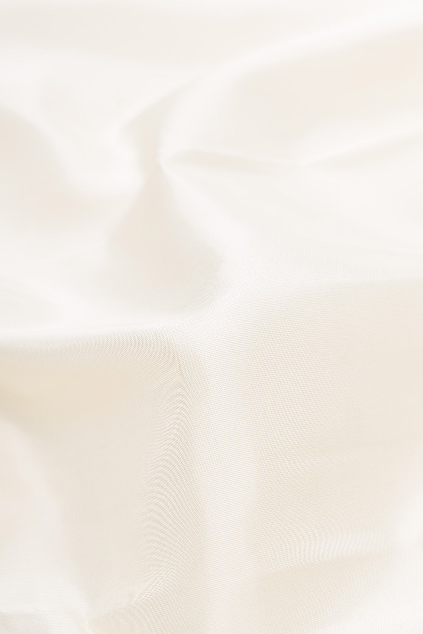 Close up of Off White Dual Tone Kanchipuram Silk Saree with Plain Body and Temple Border displaying folds