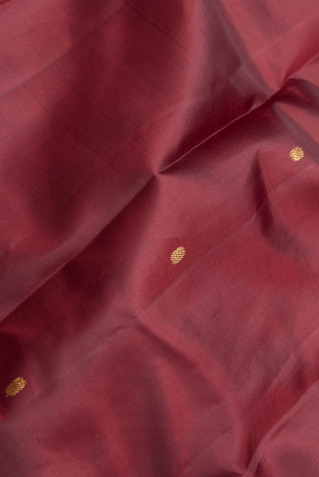Close up of Maroon Dual Tone Kanchipuram Silk Saree with Zari Butta on the body and Zari Border.  displaying folds