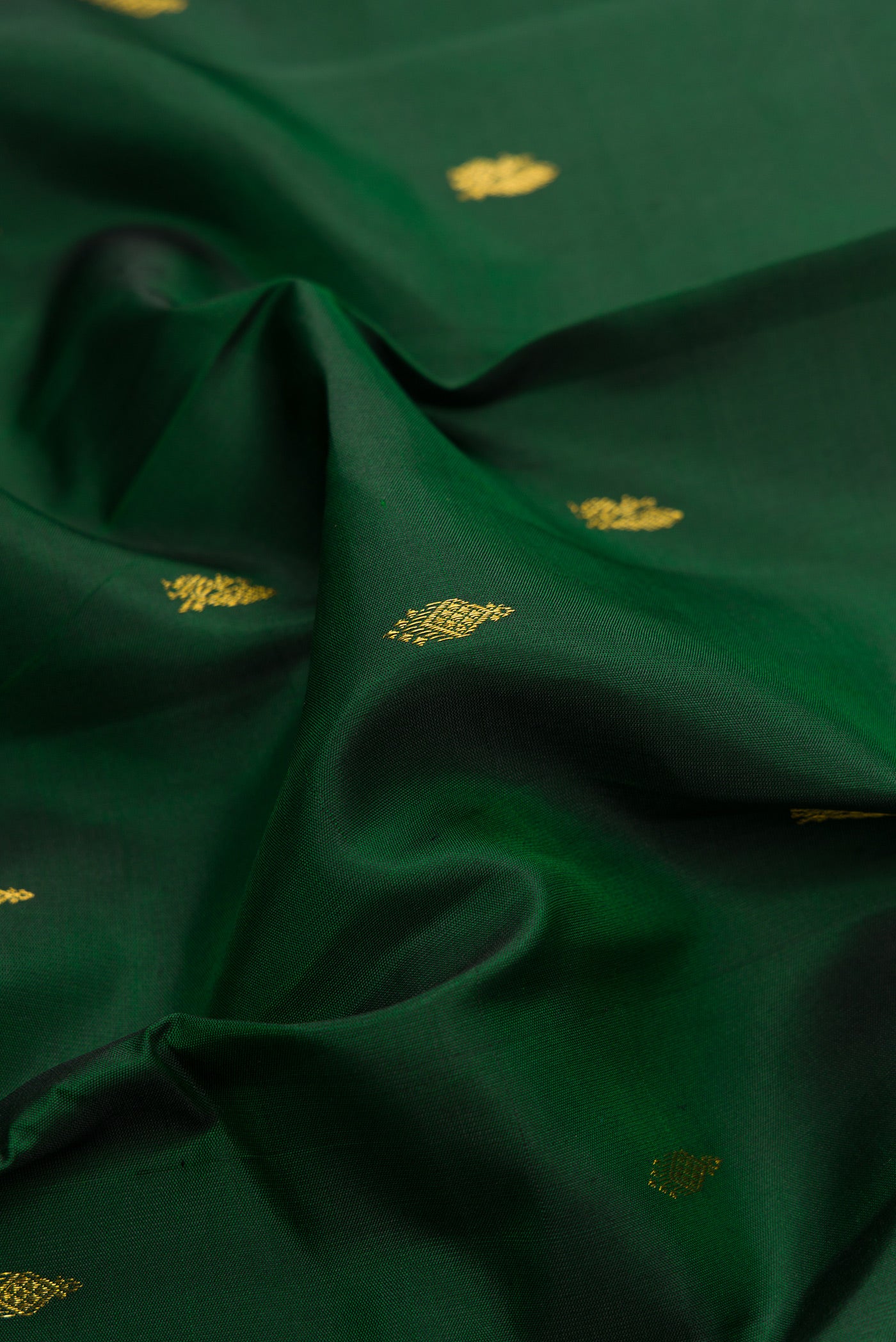 Close up of Bottle Green Dual Tone Kanchipuram Silk Saree with Zari Butta on the body and Zari Border.  displaying folds