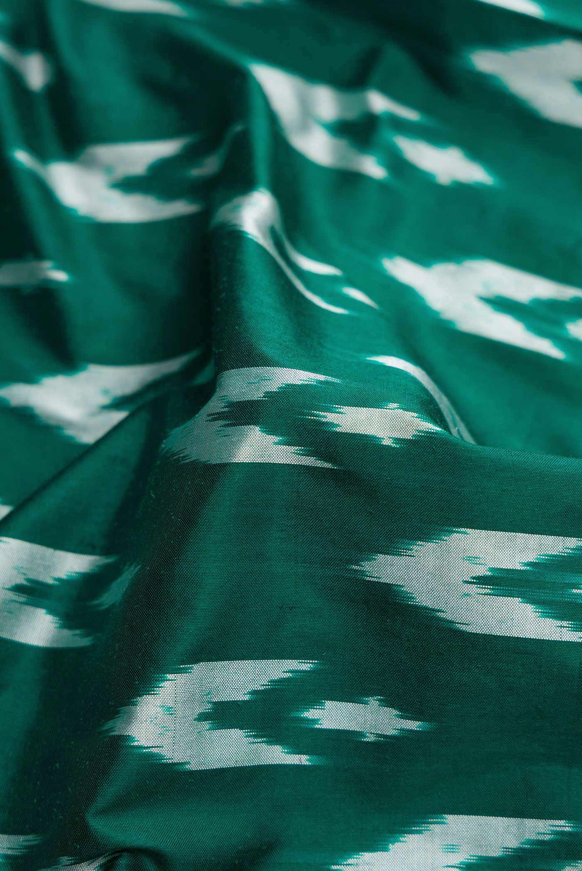 Close up of Green Pochampally Silk Saree with Pure Ikat on the body and Ikat Border displaying folds