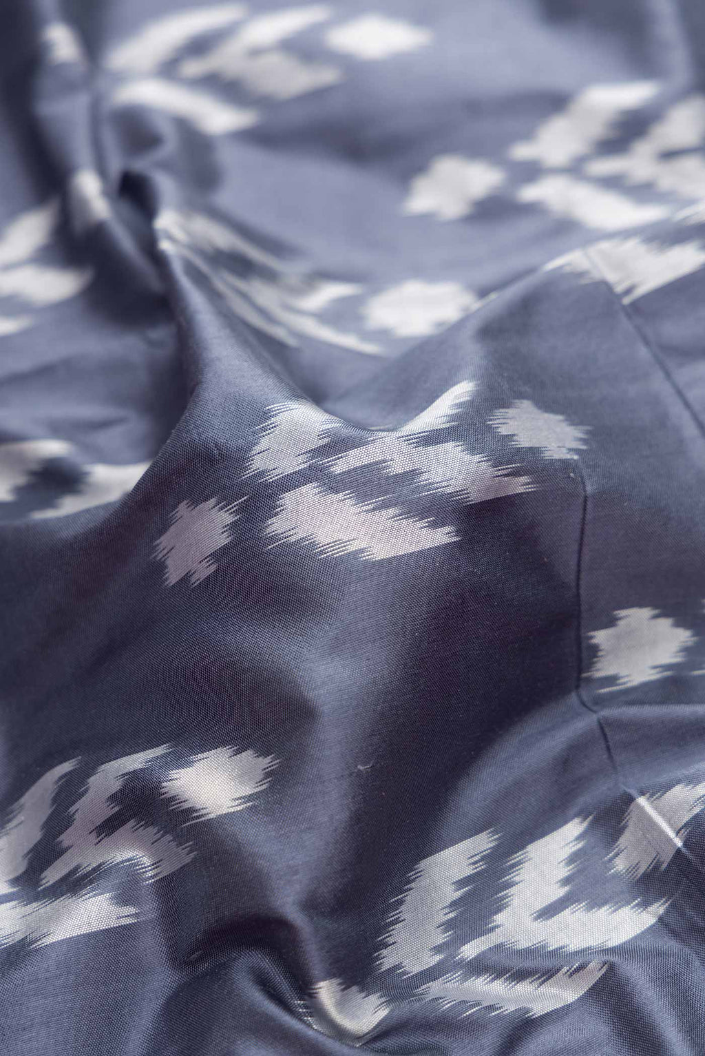 Close up of Grey Dual Tone Double Ikat Saree with Ikat Print on the body and Ikat Border.  displaying folds