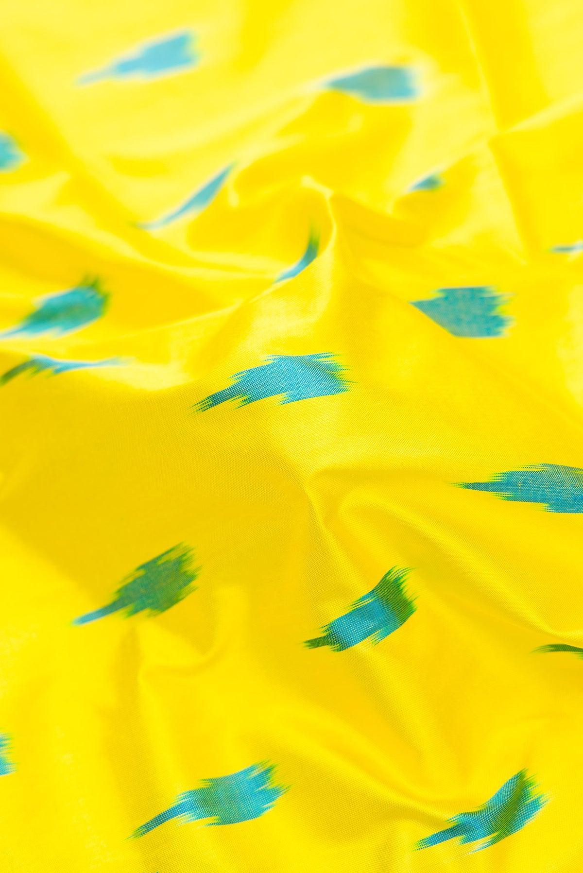 Close up of Lemon Yellow Pochampally Silk Saree with Pure Ikat on the body and Zari Border displaying folds