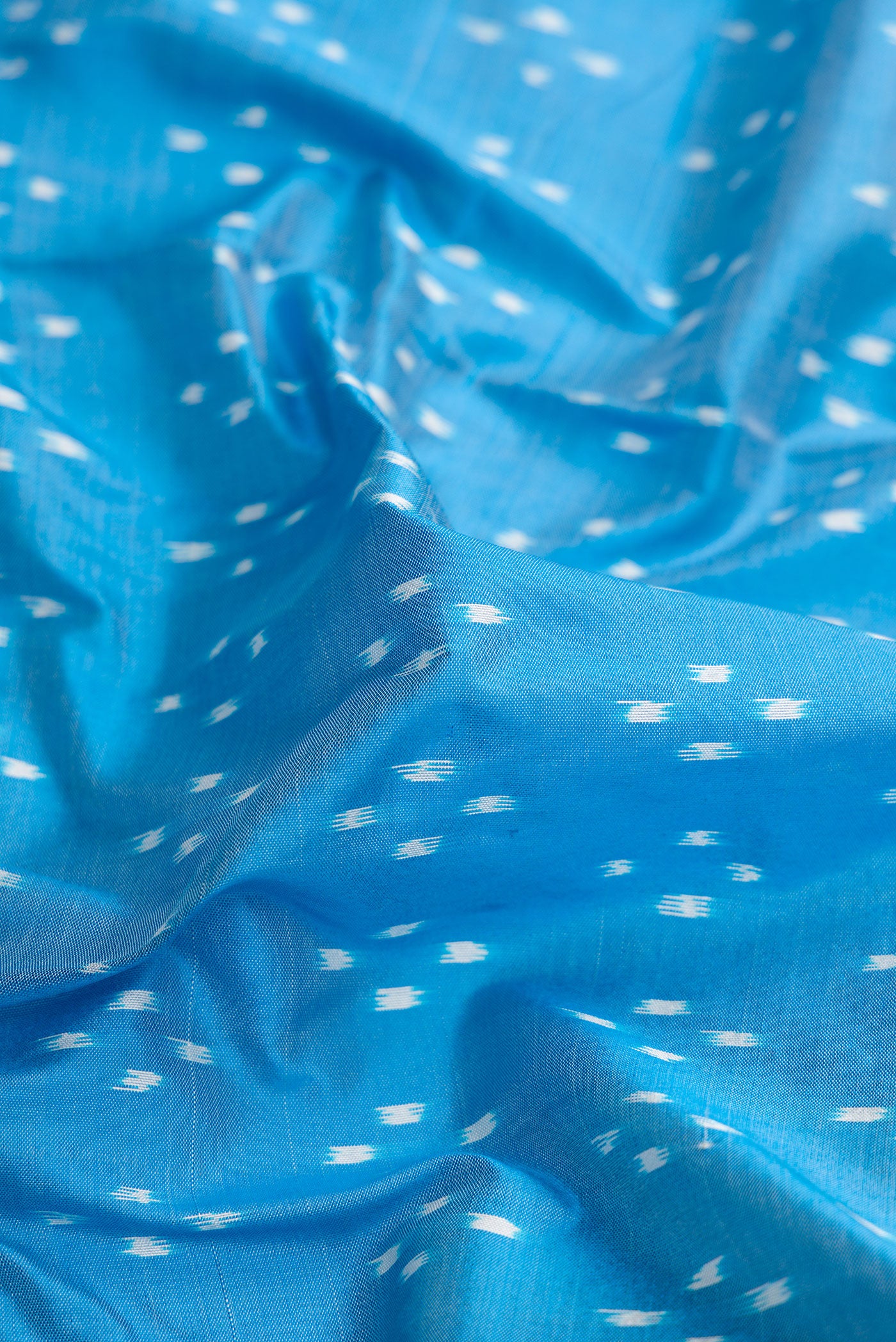 Close up of Sky Blue Dual Tone Double Ikat Saree with Ikat Print on the body and Zari Border.  displaying folds