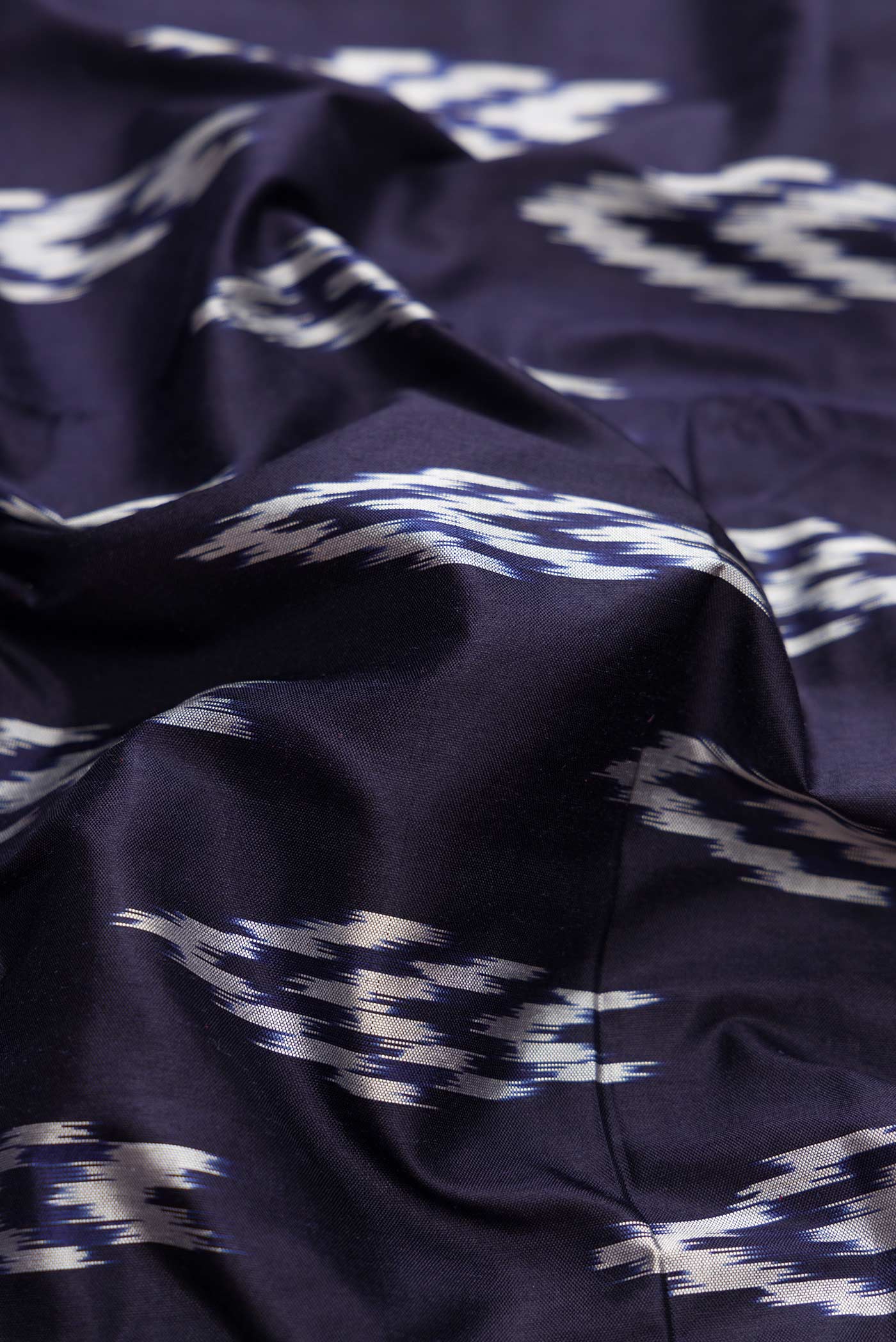 Close up of Navy Blue Dual Tone Double Ikat Saree with Ikat Print on the body and Ikat Border.  displaying folds