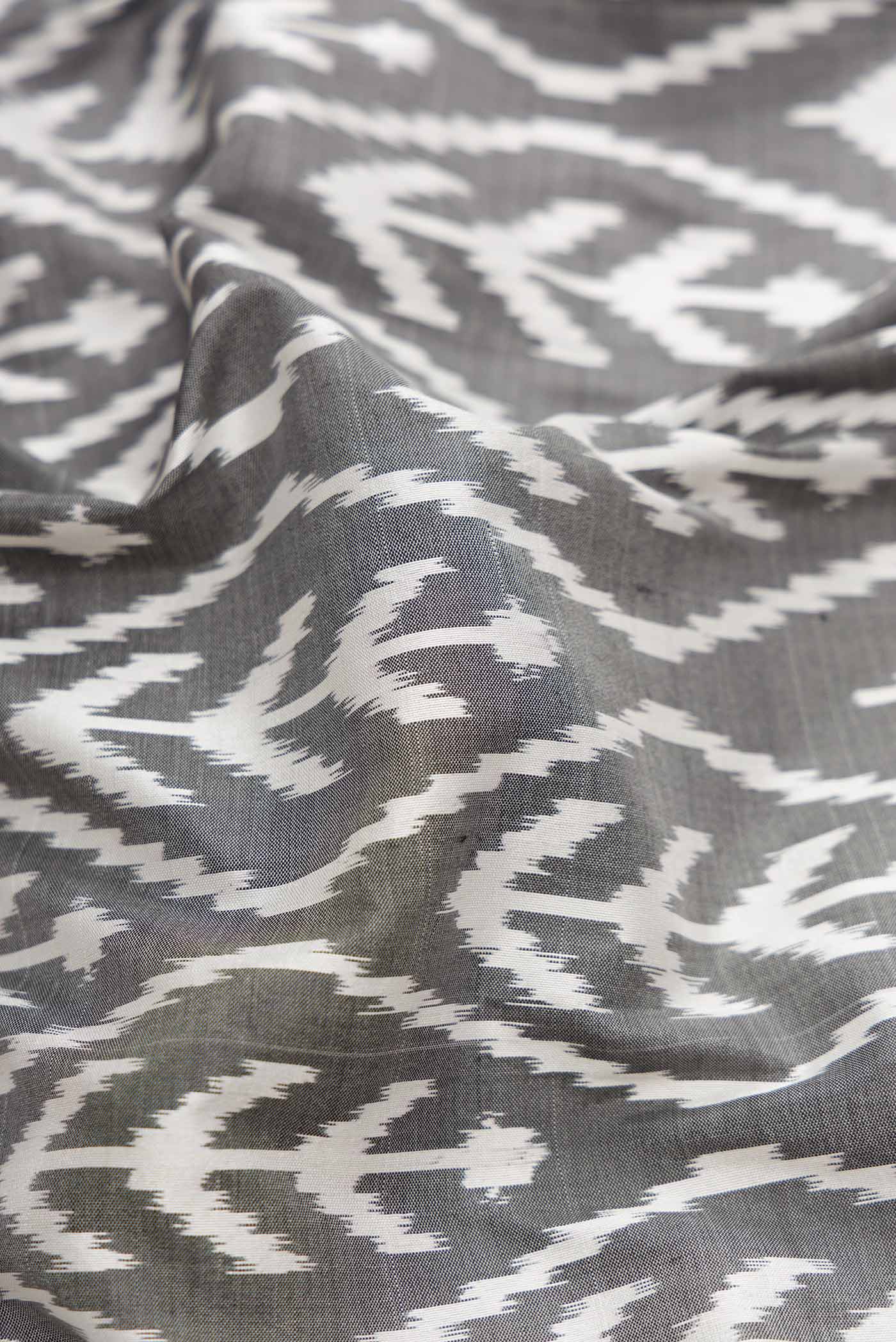Close up of Grey Pochampally Silk Saree with Pure Ikat on the body and Zari Border displaying folds