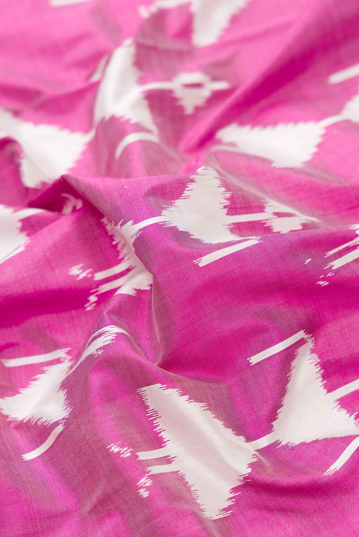Close up of Pink Dual Tone Double Ikat Saree with Ikat Print on the body and Zari Border.  displaying folds