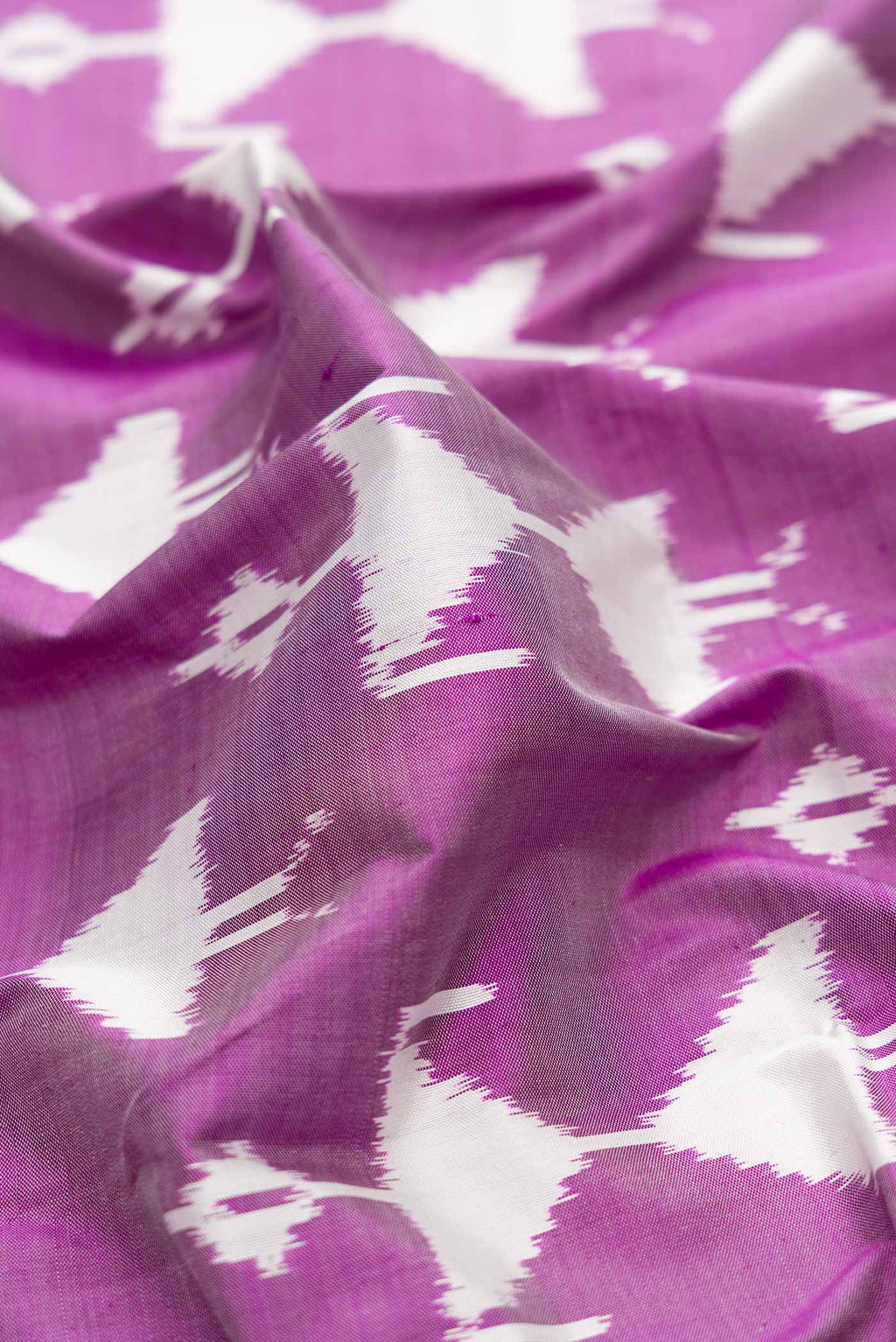 Close up of Purple Dual Tone Double Ikat Saree with Ikat Print on the body and Zari Border.  displaying folds