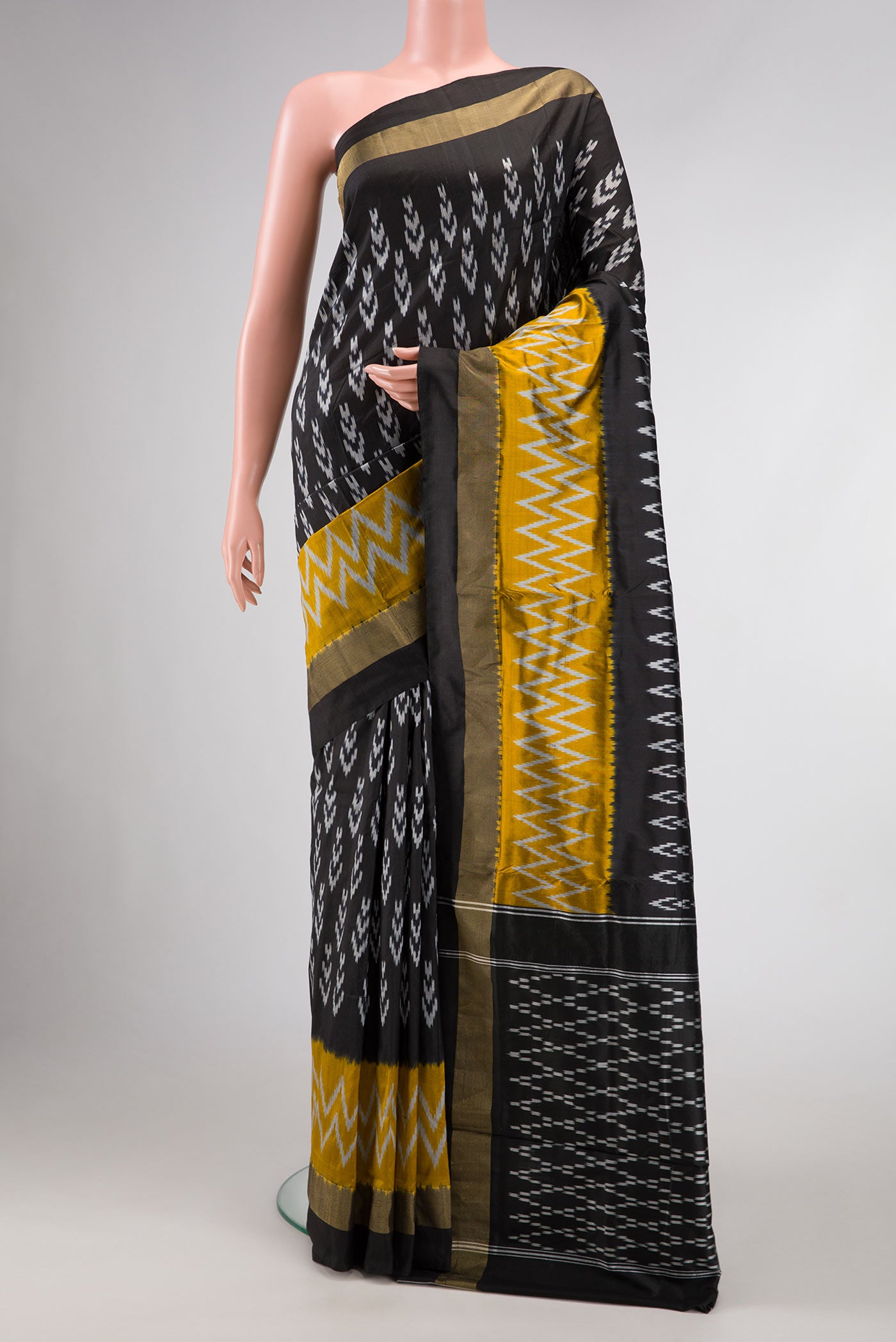 Black Dual Tone Double Ikat Saree with Ikat Print on the body and Ikat Border.  displayed on a mannequin