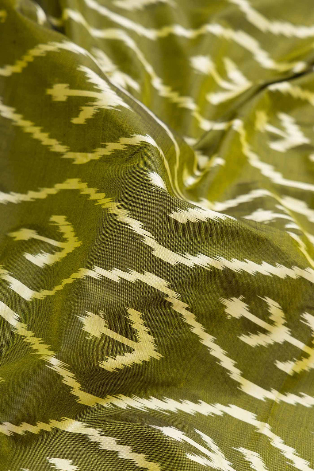 Close up of Pure Silk Pure Zari Mehandi Green Pochampally Saree with Pure Ikat on the body and Zari Border displaying folds
