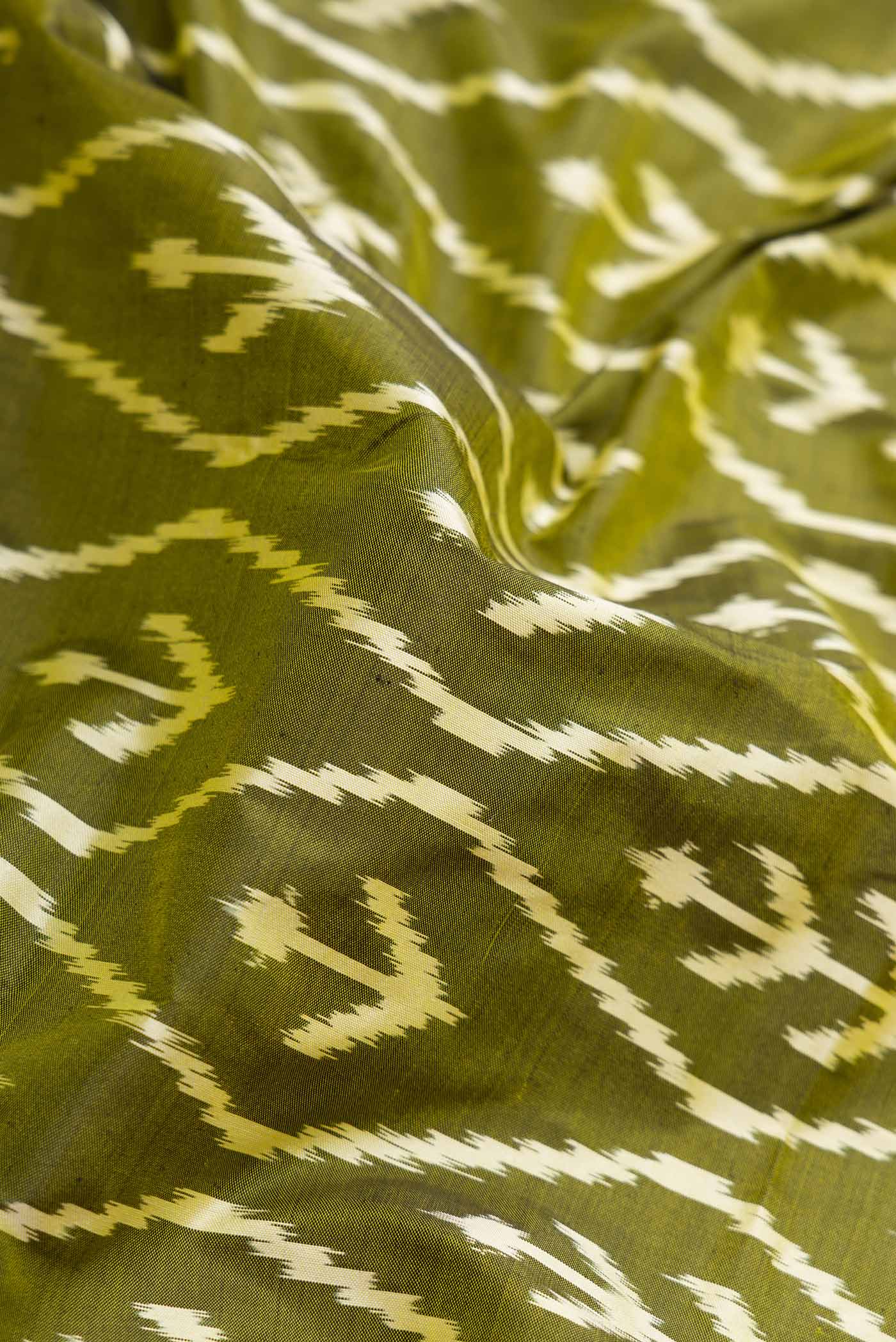 Close up of Pure Silk Pure Zari Mehandi Green Pochampally Saree with Pure Ikat on the body and Zari Border displaying folds