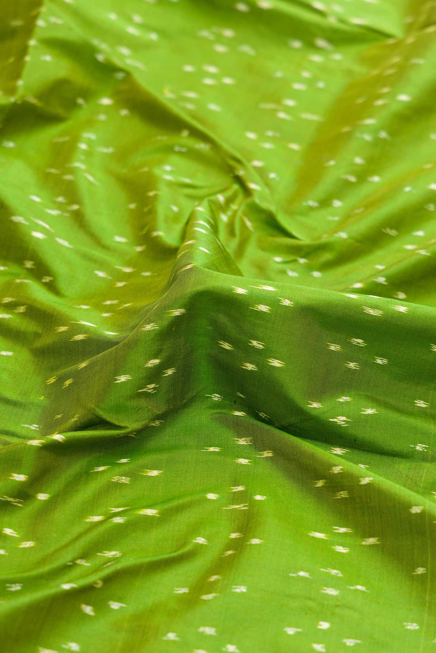 Close up of Green Dual Tone Double Ikat Saree with Ikat Print on the body and Fancy Border.  displaying folds