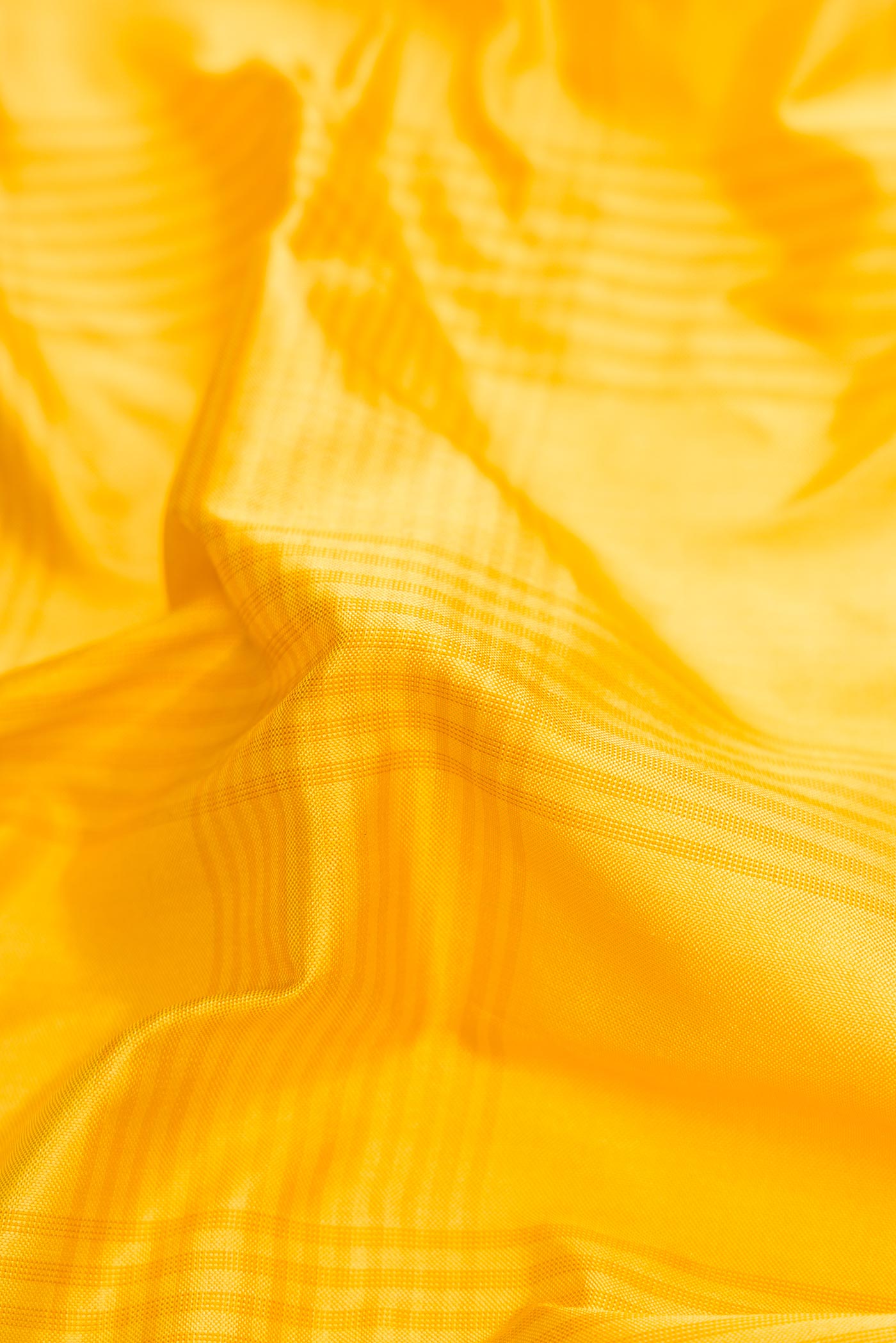 Close up of Yellow Pochampally Silk Saree with Checked design on the body and Ikat Border displaying folds