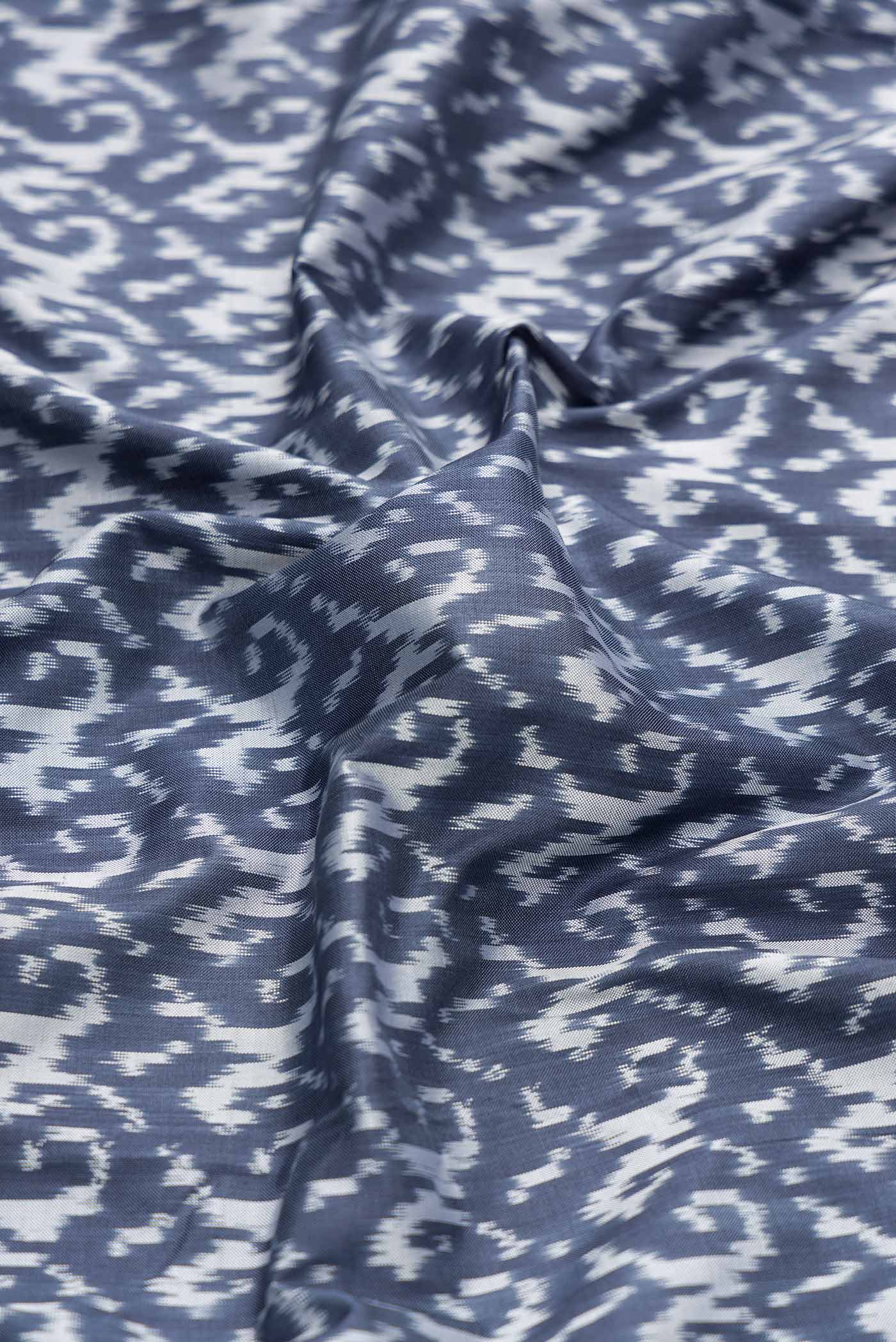 Close up of Grey Dual Tone Double Ikat Saree with Ikat Print on the body and Ikat Border displaying folds
