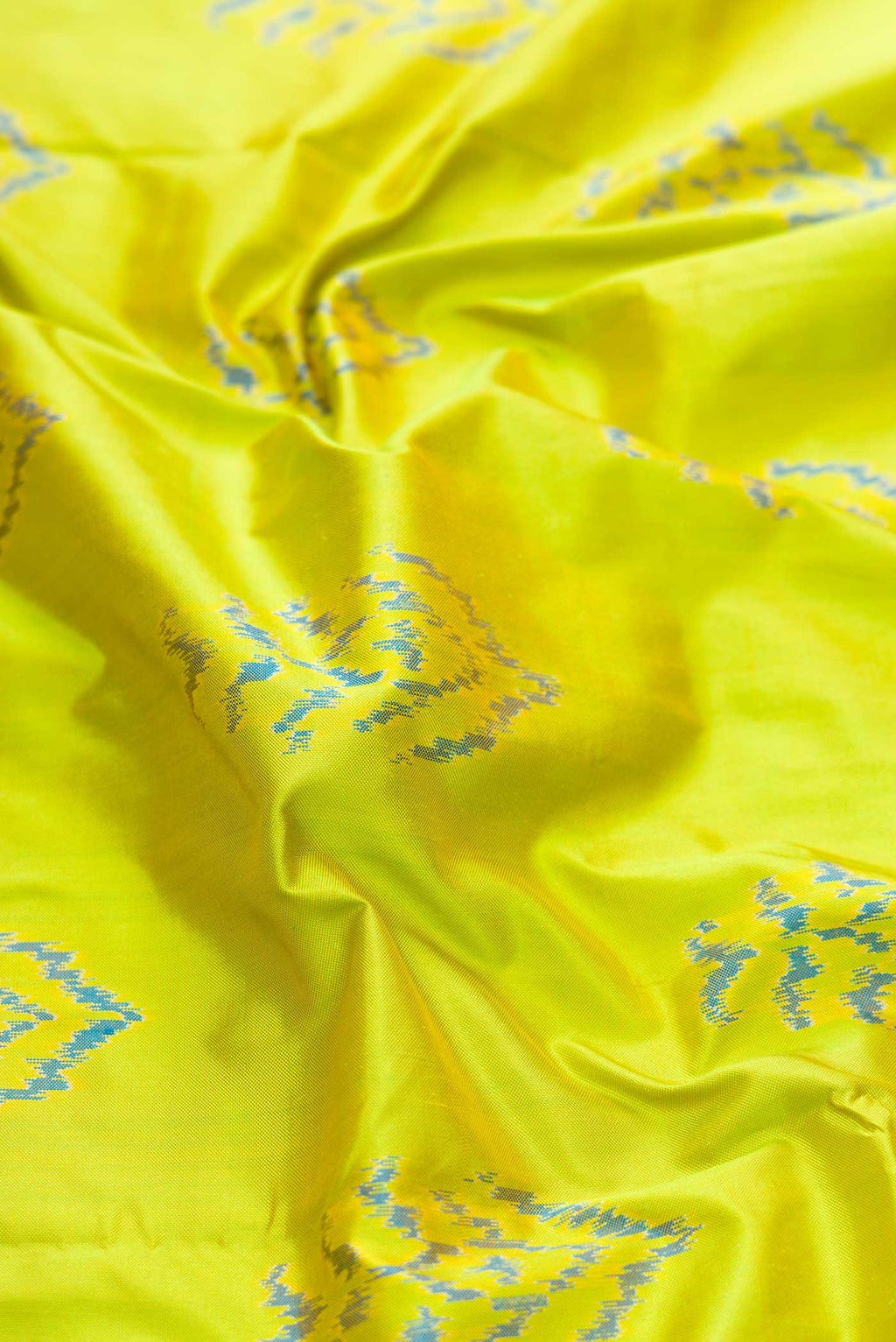 Close up of Parrot Green Dual Tone Double Ikat Saree with Ikat Print on the body and Ikat Border displaying folds