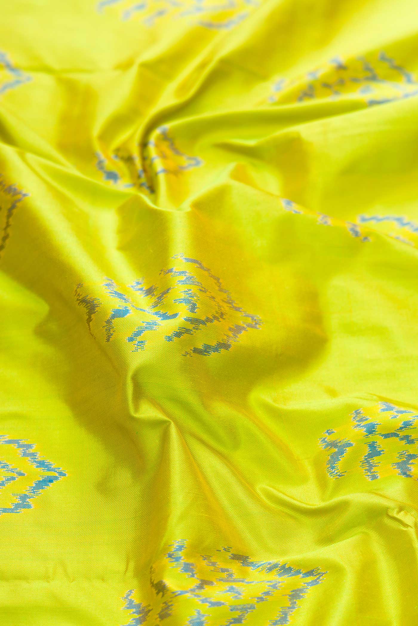 Close up of Parrot Green Dual Tone Double Ikat Saree with Ikat Print on the body and Ikat Border displaying folds