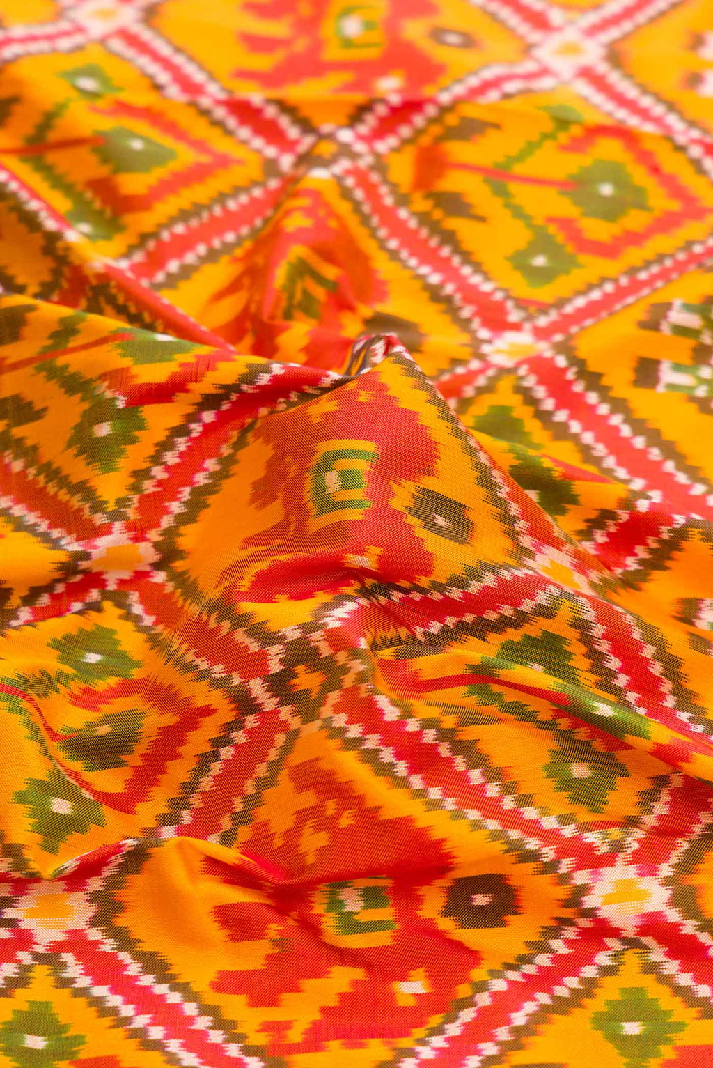 Close up of Yellow Dual Tone Double Ikat Saree with Ikat Print on the body and Thread Border displaying folds