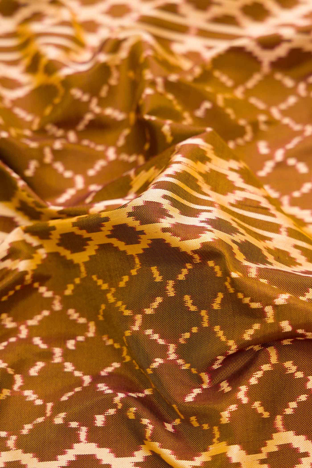Close up of Mehandi Green Dual Tone Double Ikat Saree with Ikat Print on the body and Zari Border.  displaying folds