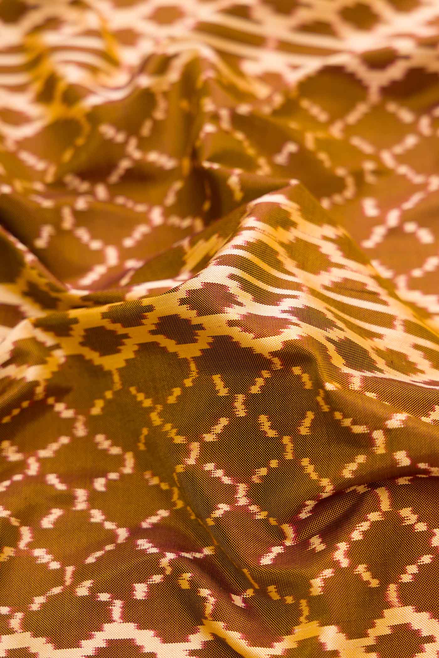 Close up of Mehandi Green Dual Tone Double Ikat Saree with Ikat Print on the body and Zari Border.  displaying folds