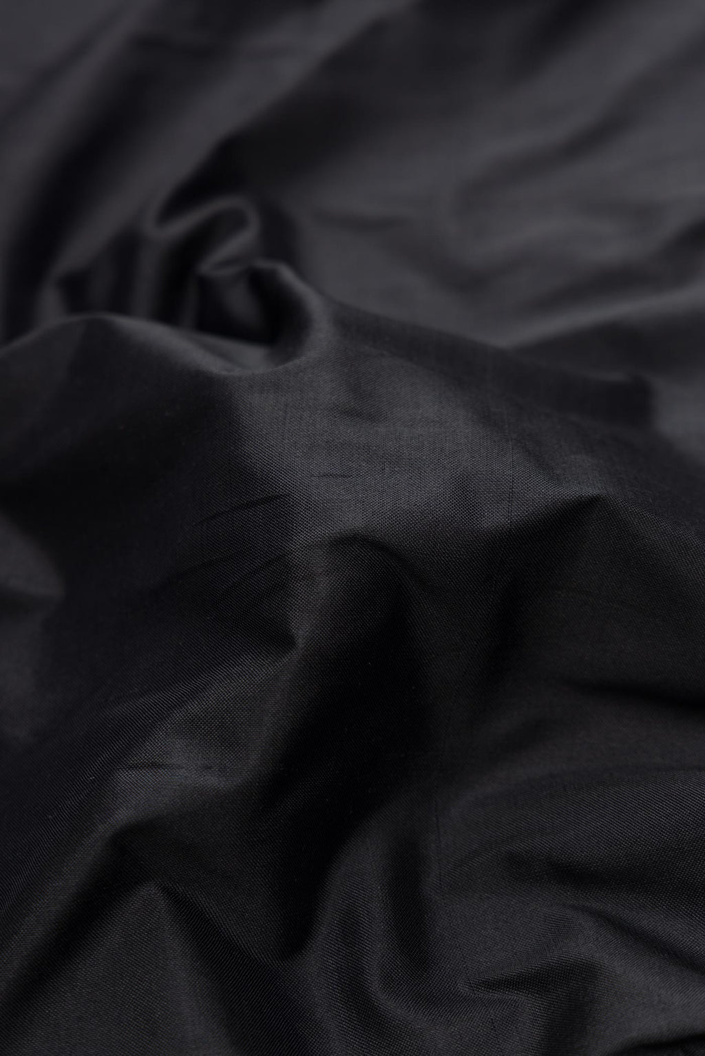 Close up of Black Dual Tone Double Ikat Saree with Plain Body and Ikat Border.  displaying folds