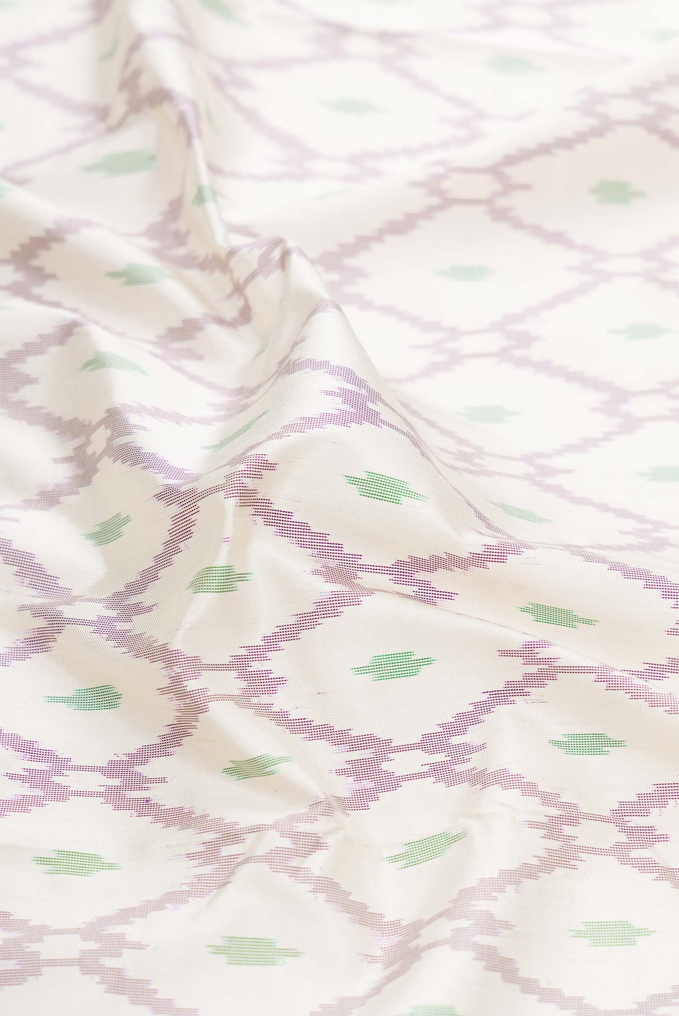 Close up of Off White Dual Tone Double Ikat Saree with Ikat Print on the body and Ikat Border displaying folds