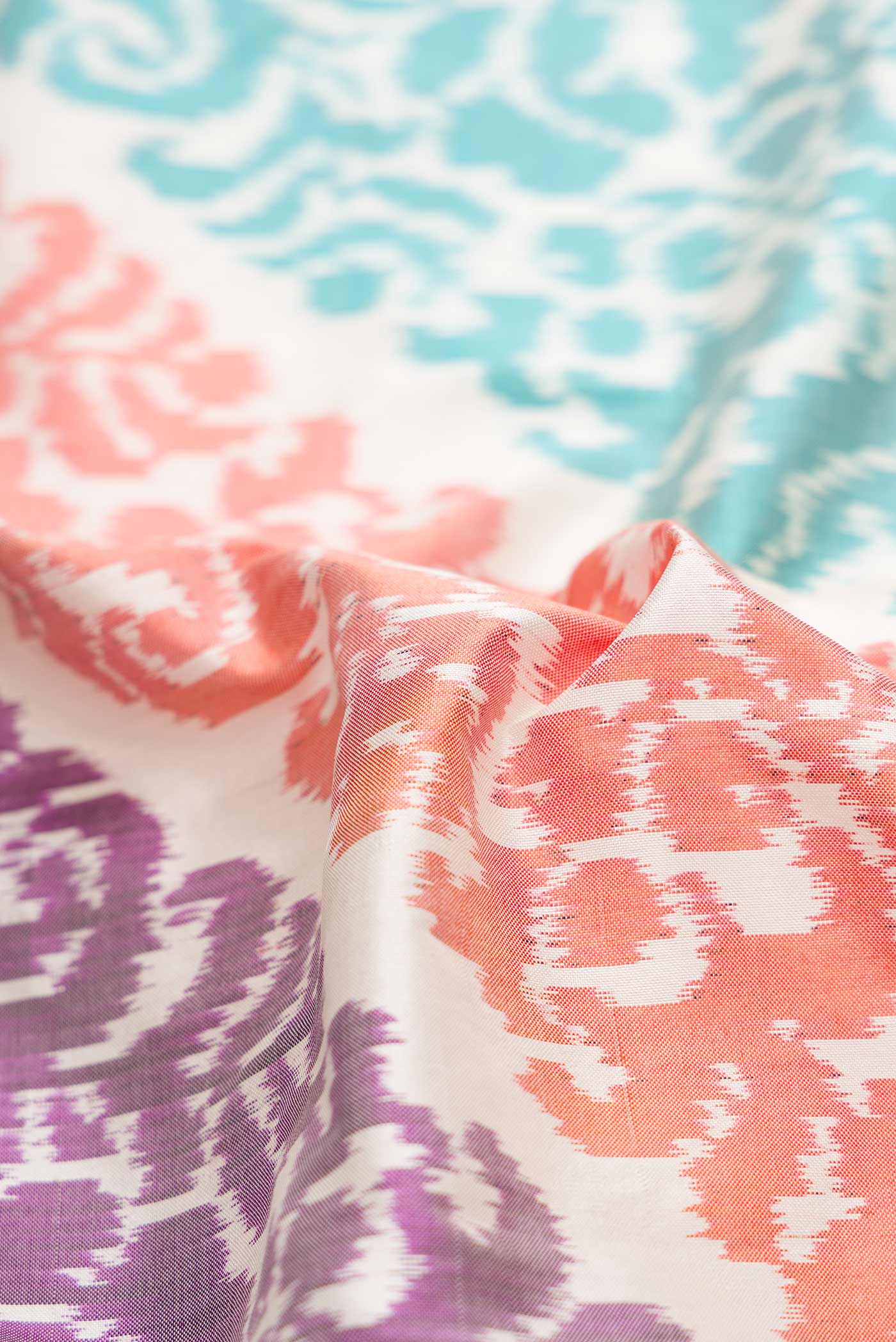 Close up of Off White Dual Tone Double Ikat Saree with Ikat Print on the body and Plain Border.  displaying folds