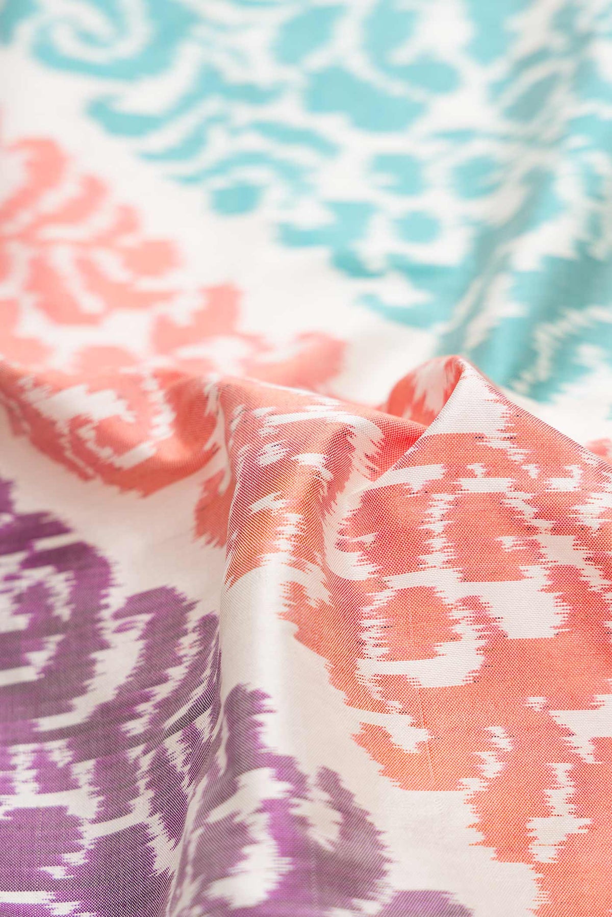 Close up of Off White Dual Tone Double Ikat Saree with Ikat Print on the body and Plain Border.  displaying folds