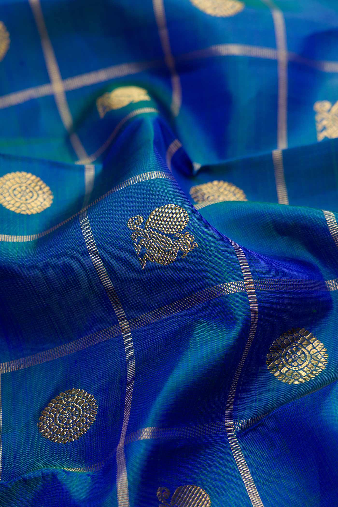 Close up of Pure Silk Pure Zari Peacock Blue Dual Tone Kanjivaram Saree with Checked design on the body and Zari Border.  displaying folds