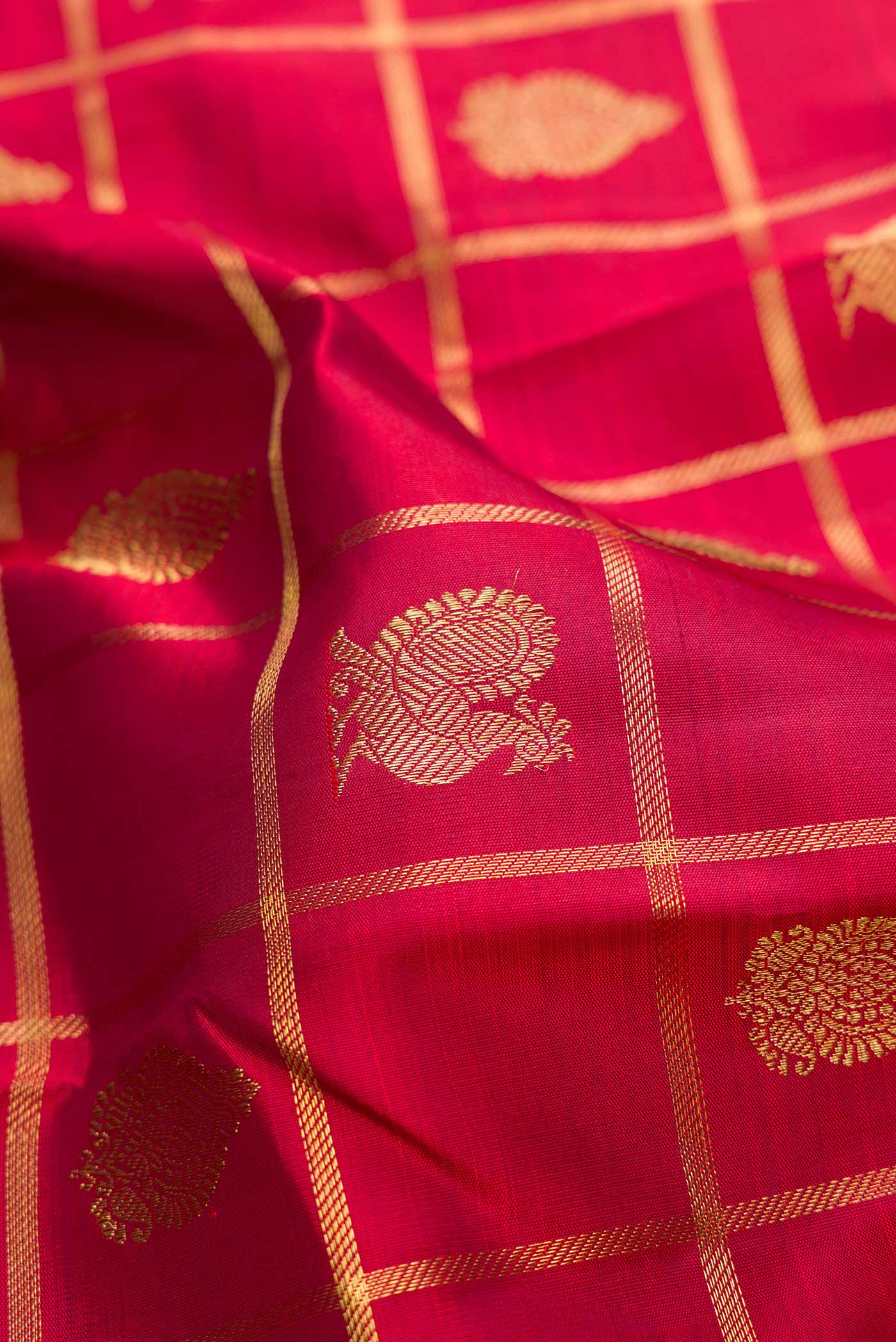 Close up of Pure Silk Pure Zari Maroon Dual Tone Kanjivaram Saree with Checked design on the body and Zari Border.  displaying folds