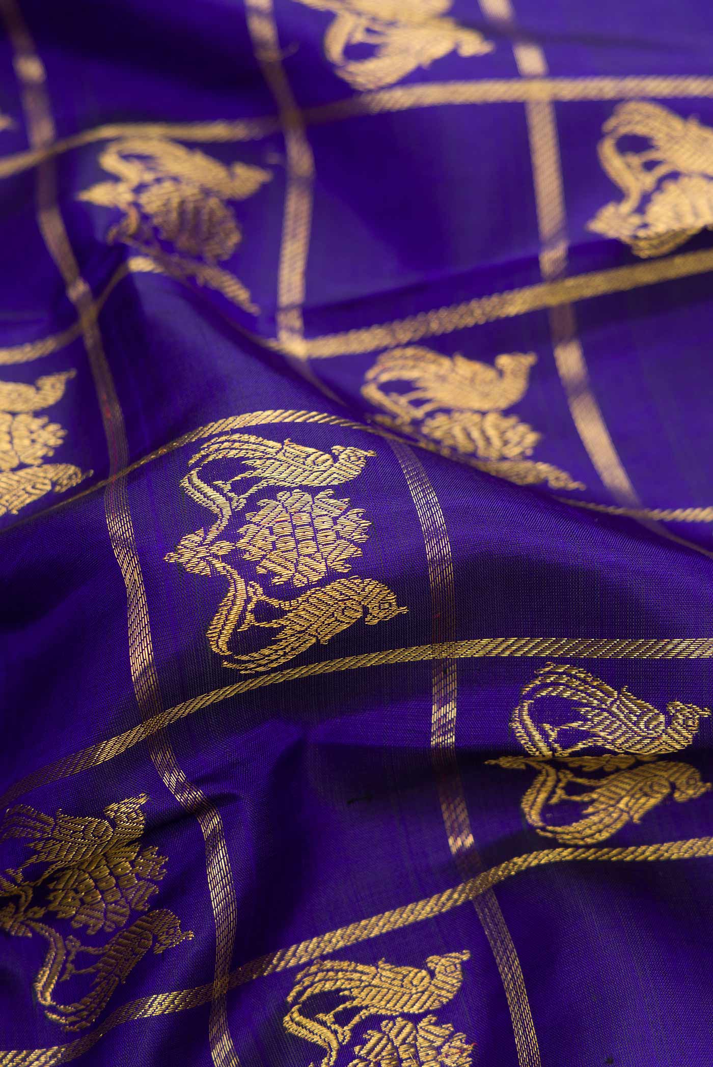 Close up of Royal Blue Dual Tone Kanjivaram Silk Saree with Checked design on the body and Zari Border.  displaying folds