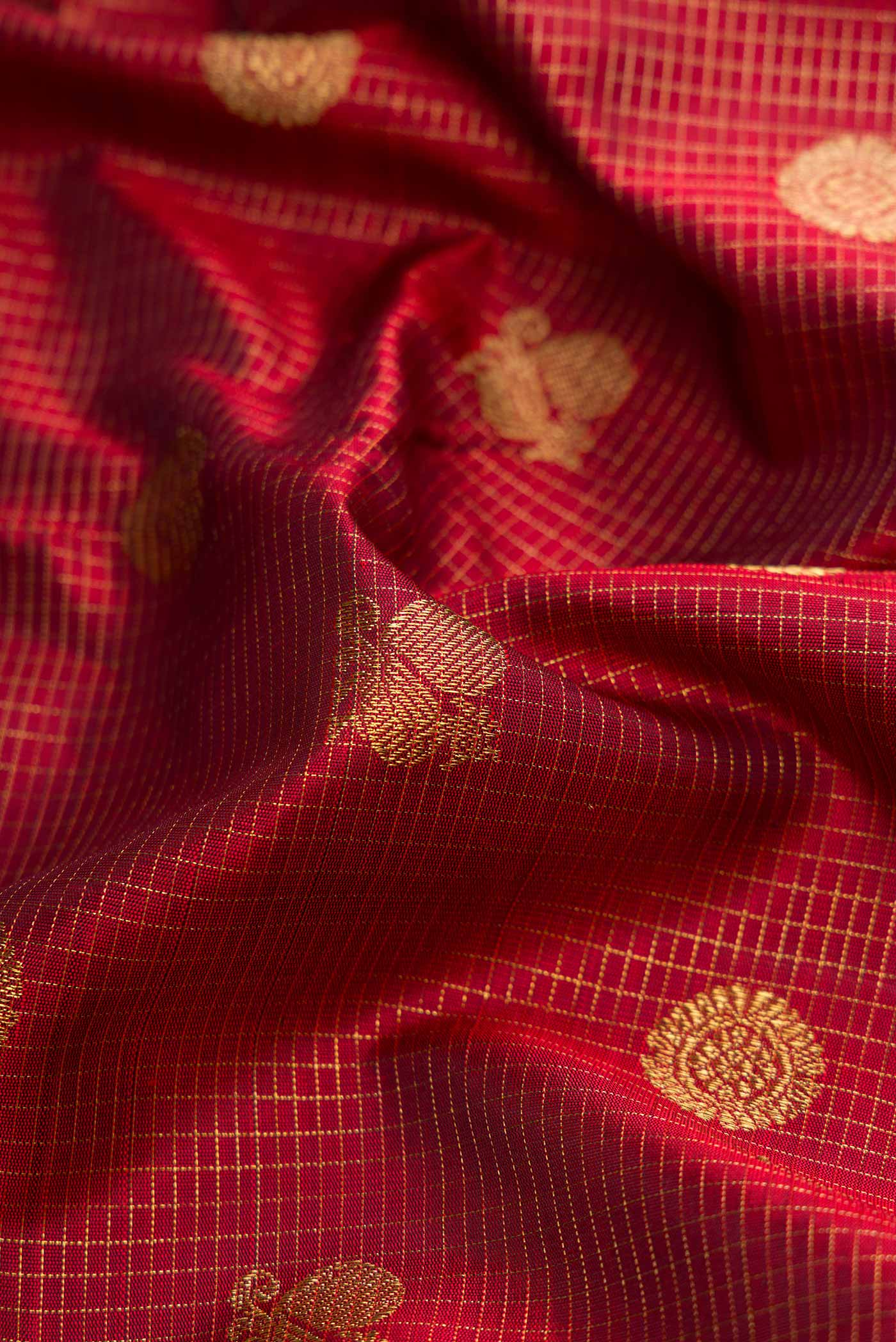 Close up of Maroon Dual Tone Kanjivaram Silk Saree with Zari Butta on the body and Zari Border.  displaying folds