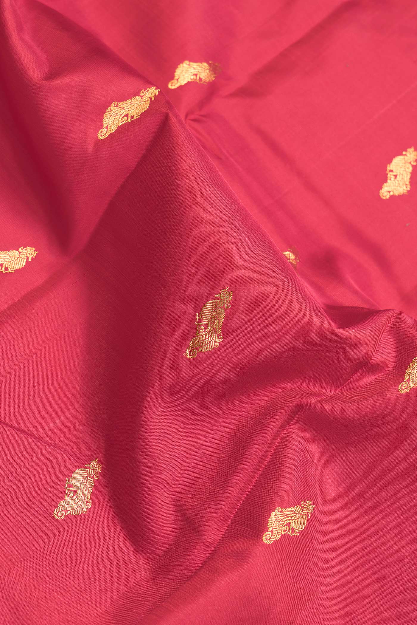 Close up of Maroon Dual Tone Kanchipuram Silk Saree with Zari Butta on the body and Zari Border.  displaying folds